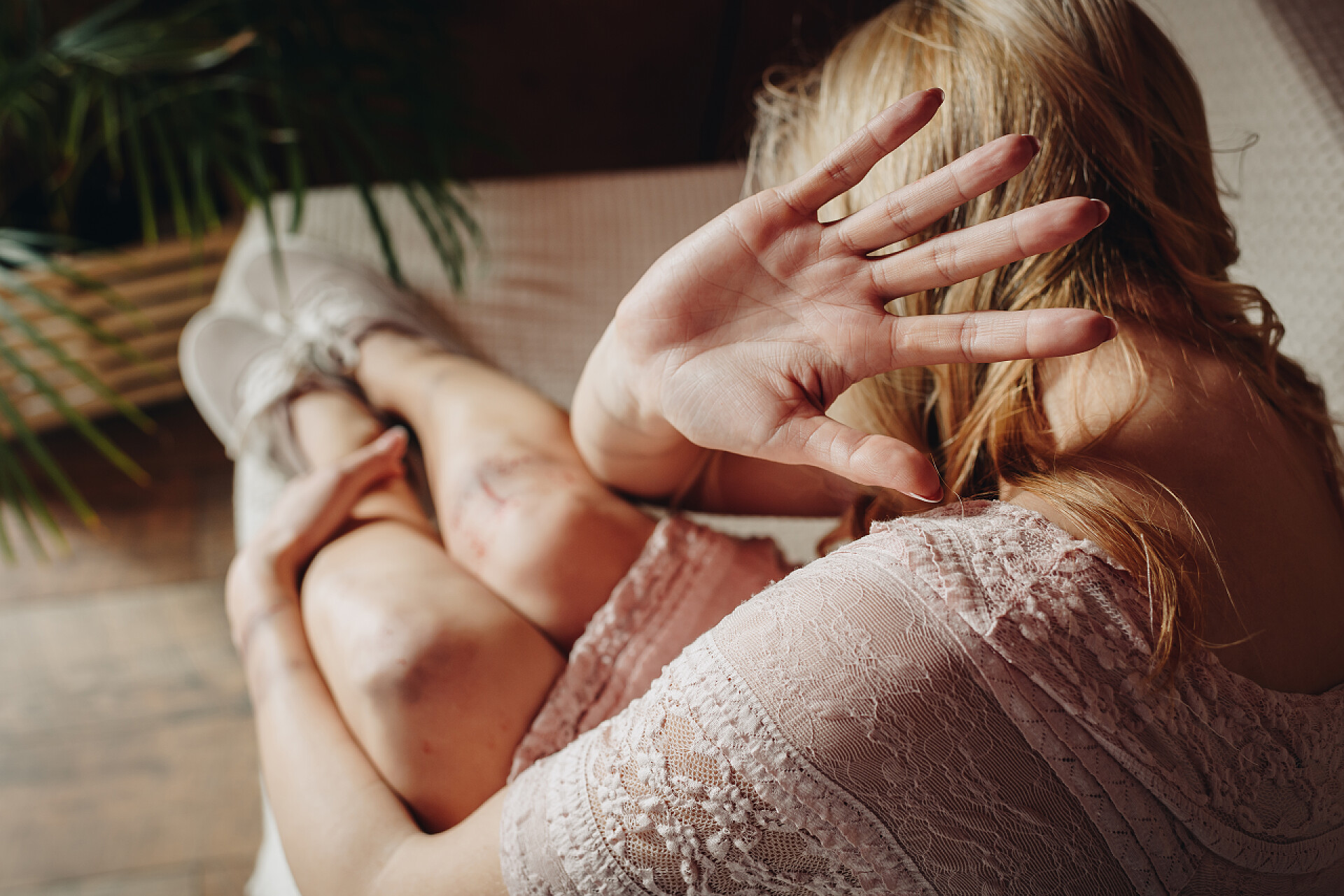 坐在地上用手捂脸的女性有选择的女性焦点，在家里停下来坐在沙发上