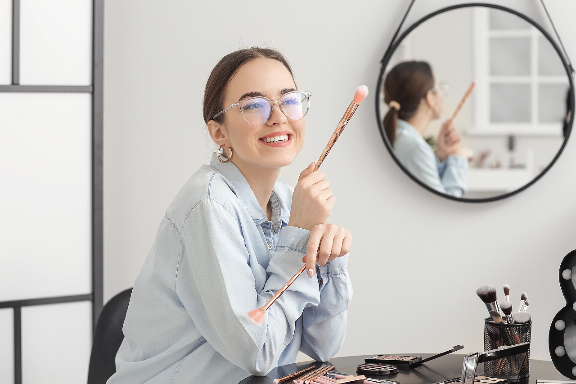 拿着化妆刷的化妆师美容院的专业女性化妆师