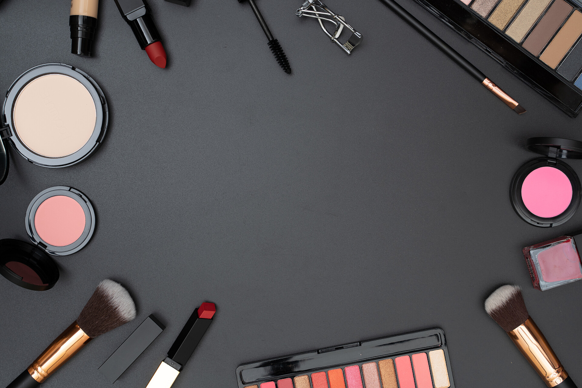 在黑色背景上的化妆刷和化妆品在黑色背景上设置文字空间的装饰化妆品