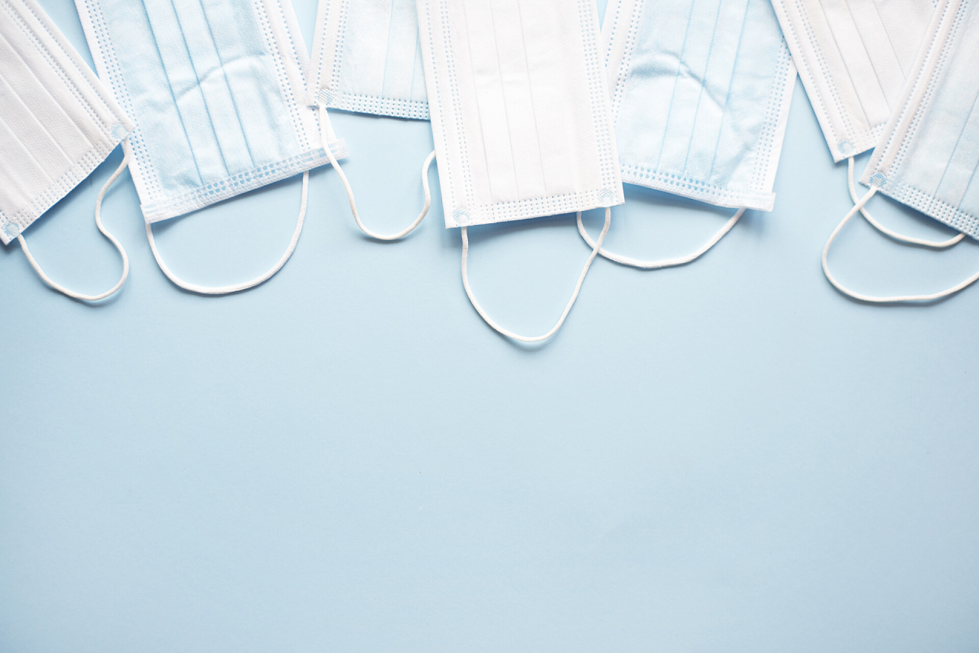 蓝色背景上的一堆口罩浅蓝色背景的医疗面罩. 