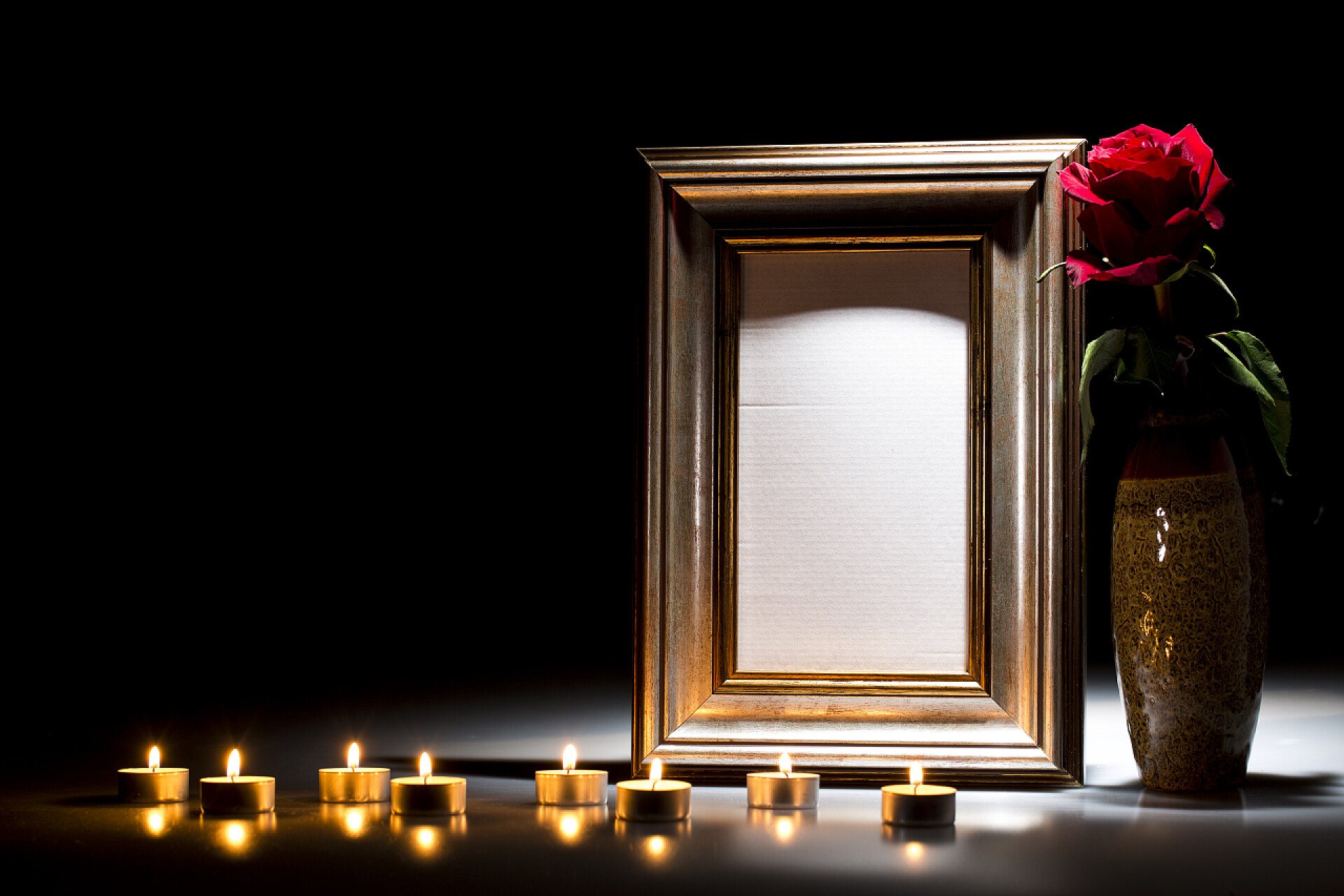黑色背景上的相框和蜡烛玫瑰花黑暗背景下同情卡的空白哀悼框架