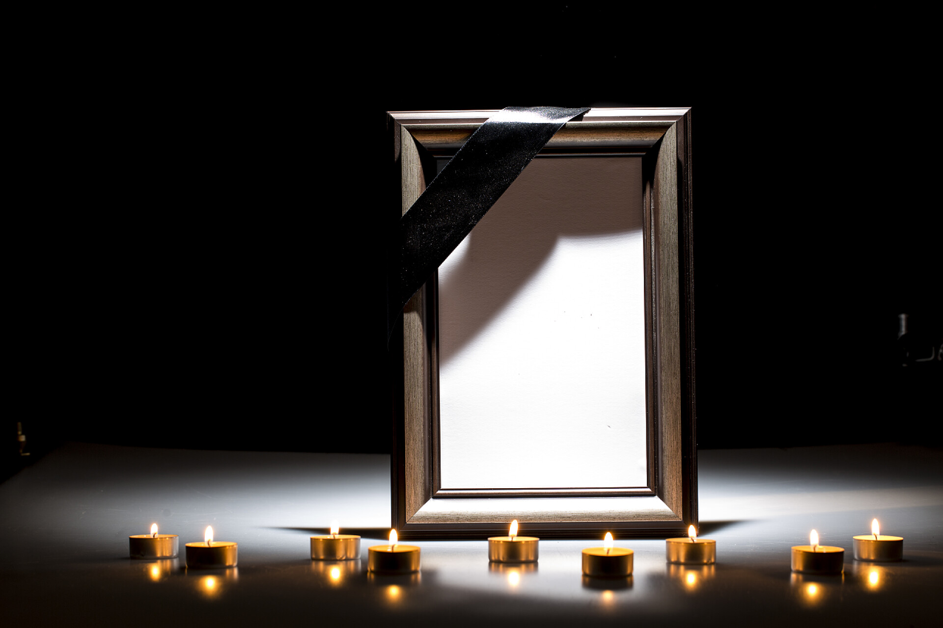 黑色背景上的相框和蜡烛黑暗背景下同情卡的空白哀悼框架