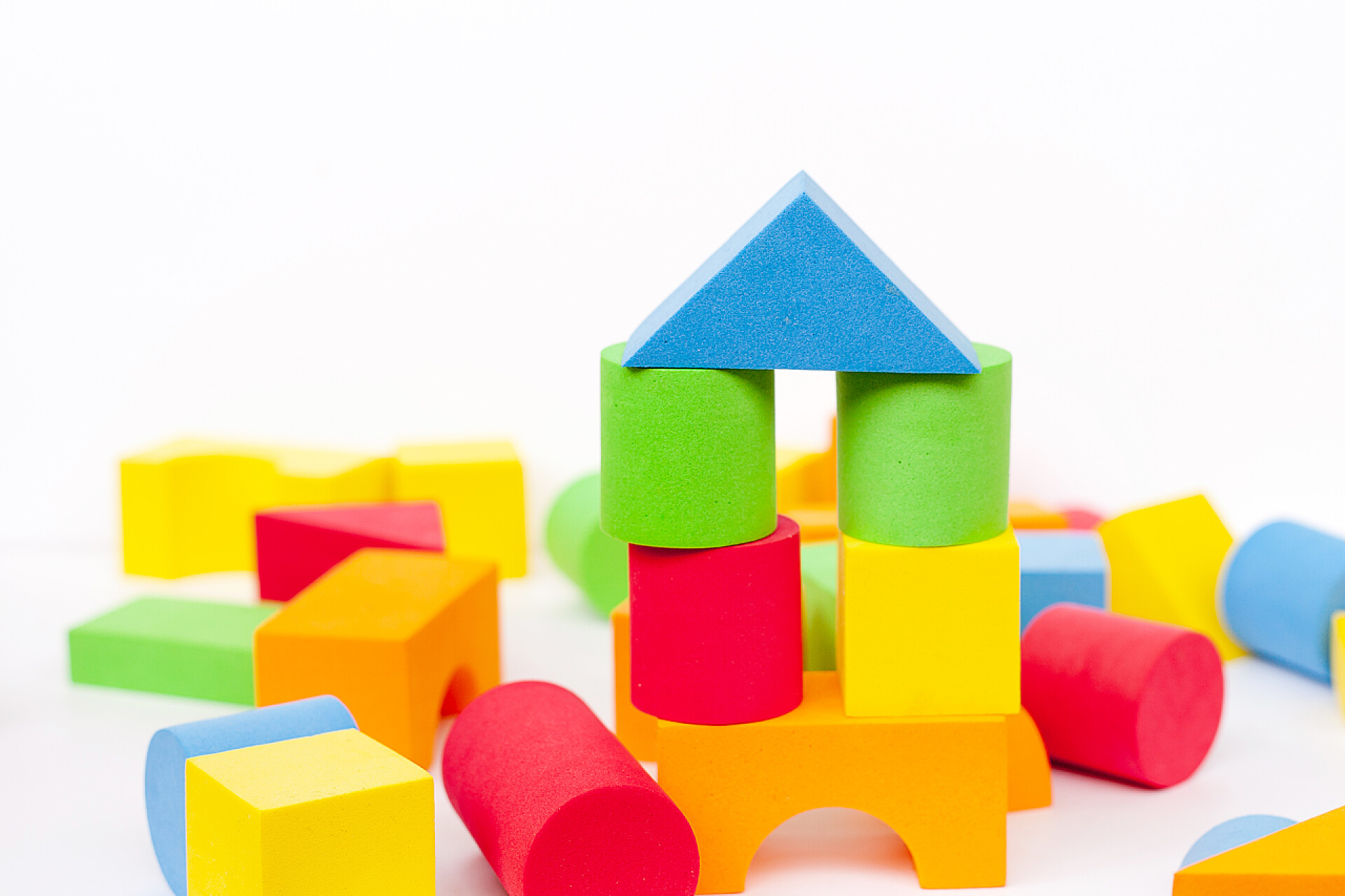 白色背景上的五彩缤纷的玩具设计人员色彩艳丽的多色彩细节。白色背景的儿童玩具。五彩缤纷的玩具形象背景. 