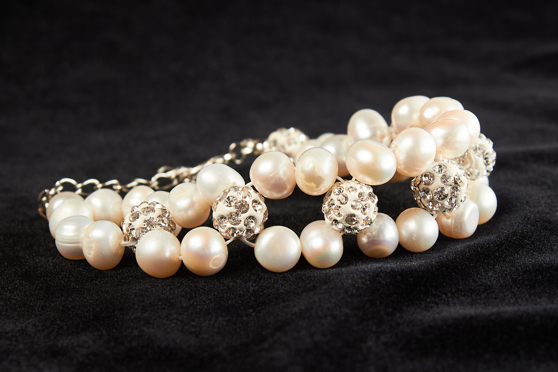 黑色天鹅绒上的粉色马略卡珍珠的手镯粉色马略卡珍珠的手镯，镶嵌在黑色天鹅绒上的半宝石。关门了