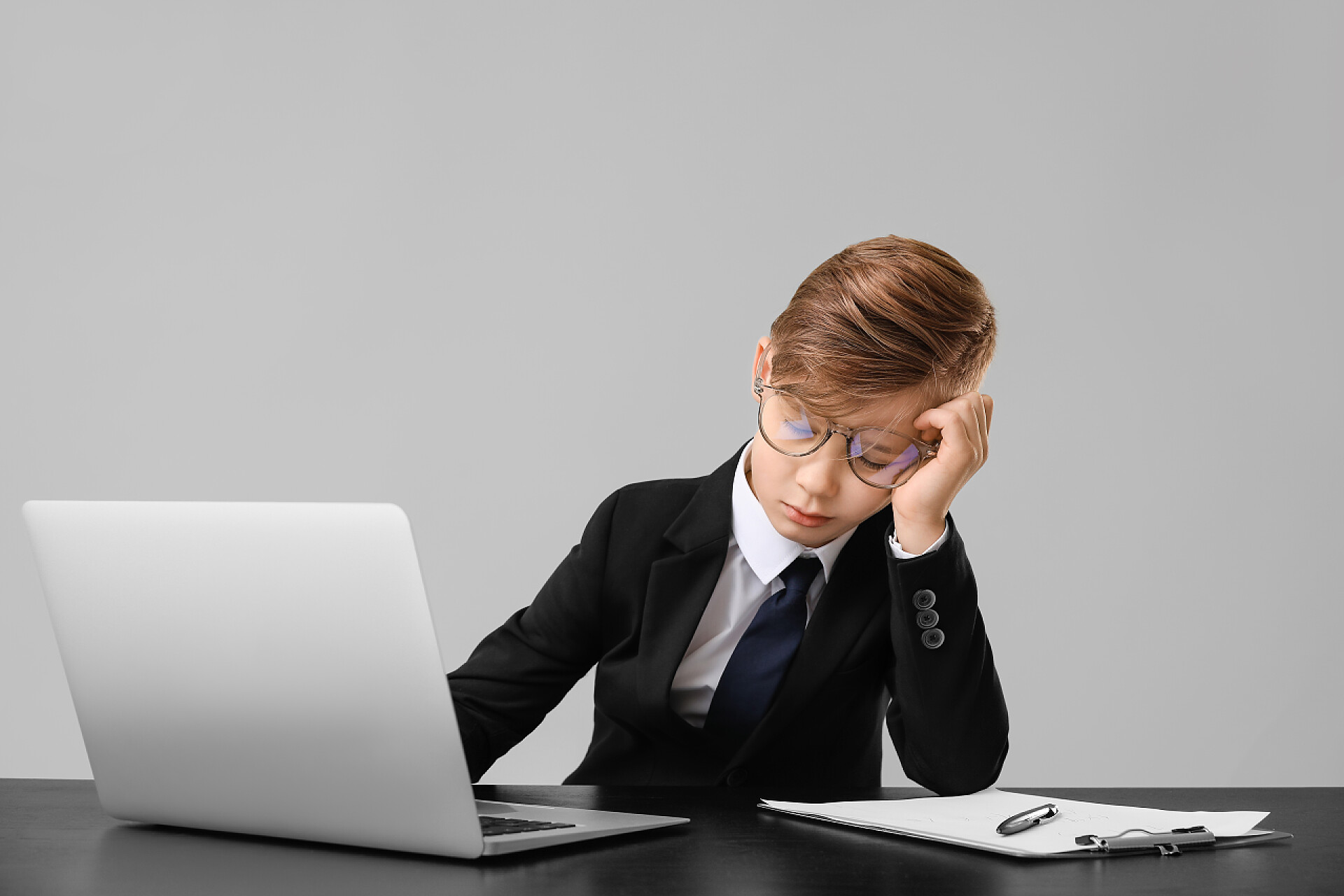 在工作场所睡觉的小秘书在灰蒙蒙的背景下坐在工作场所睡觉的小秘书