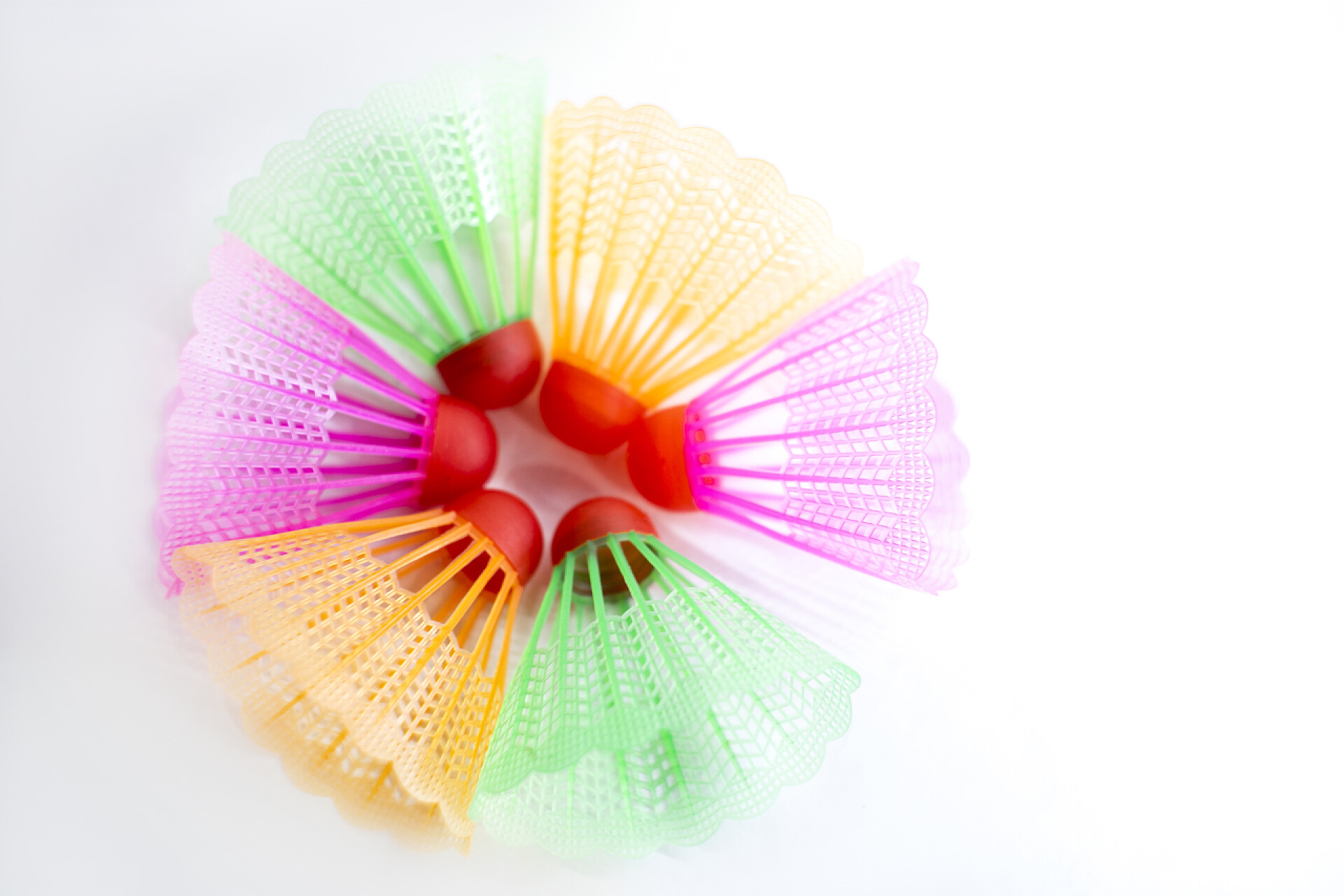 白色背景上的彩色羽毛球在白色背景上设置多色羽毛球羽毛球。平躺在床上简约主义体育、健身、健康生活方式和物体概念