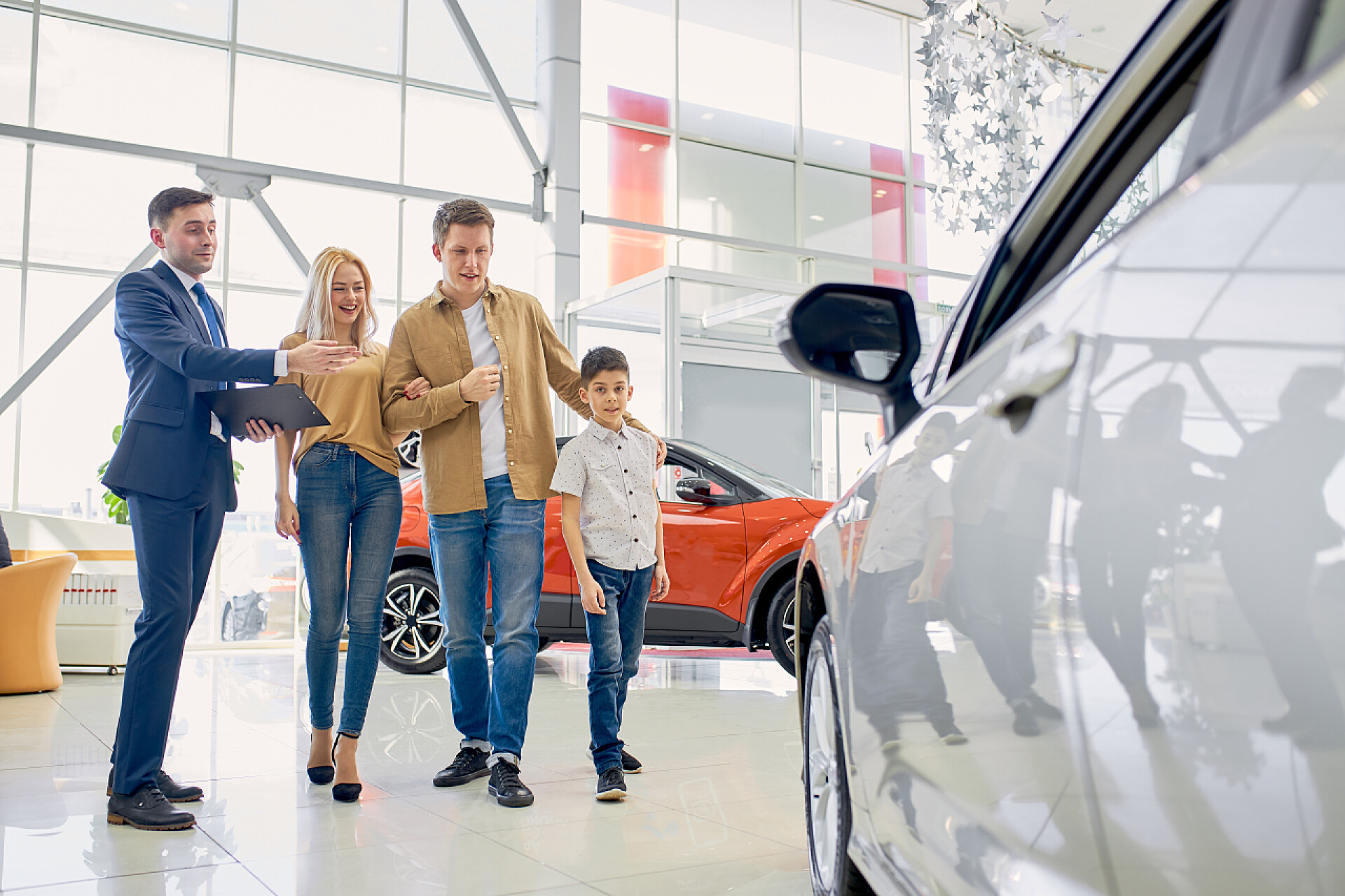 一家人在4s店看车好客的顾问为经销店的客户代表新车