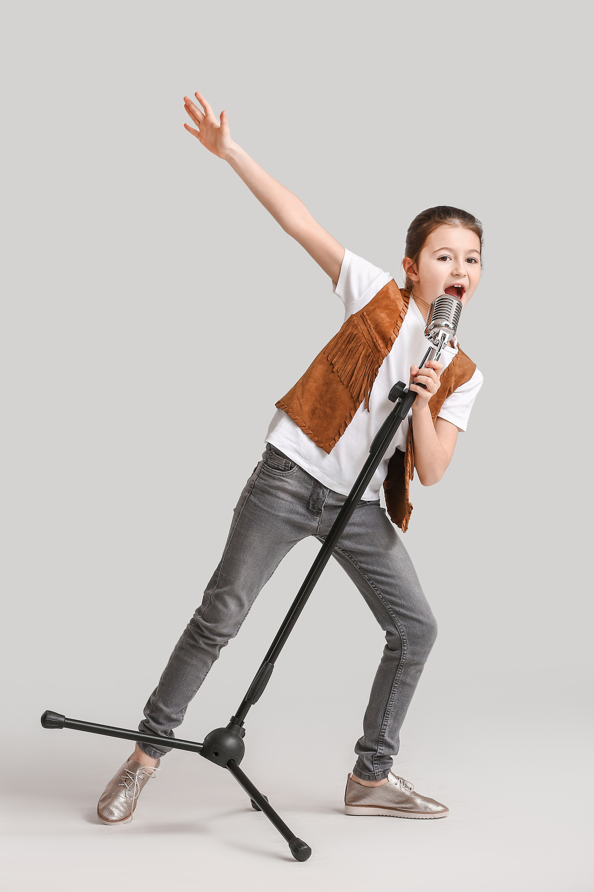 在明亮背景下唱歌的女孩可爱的小女孩在明亮的背景下歌唱