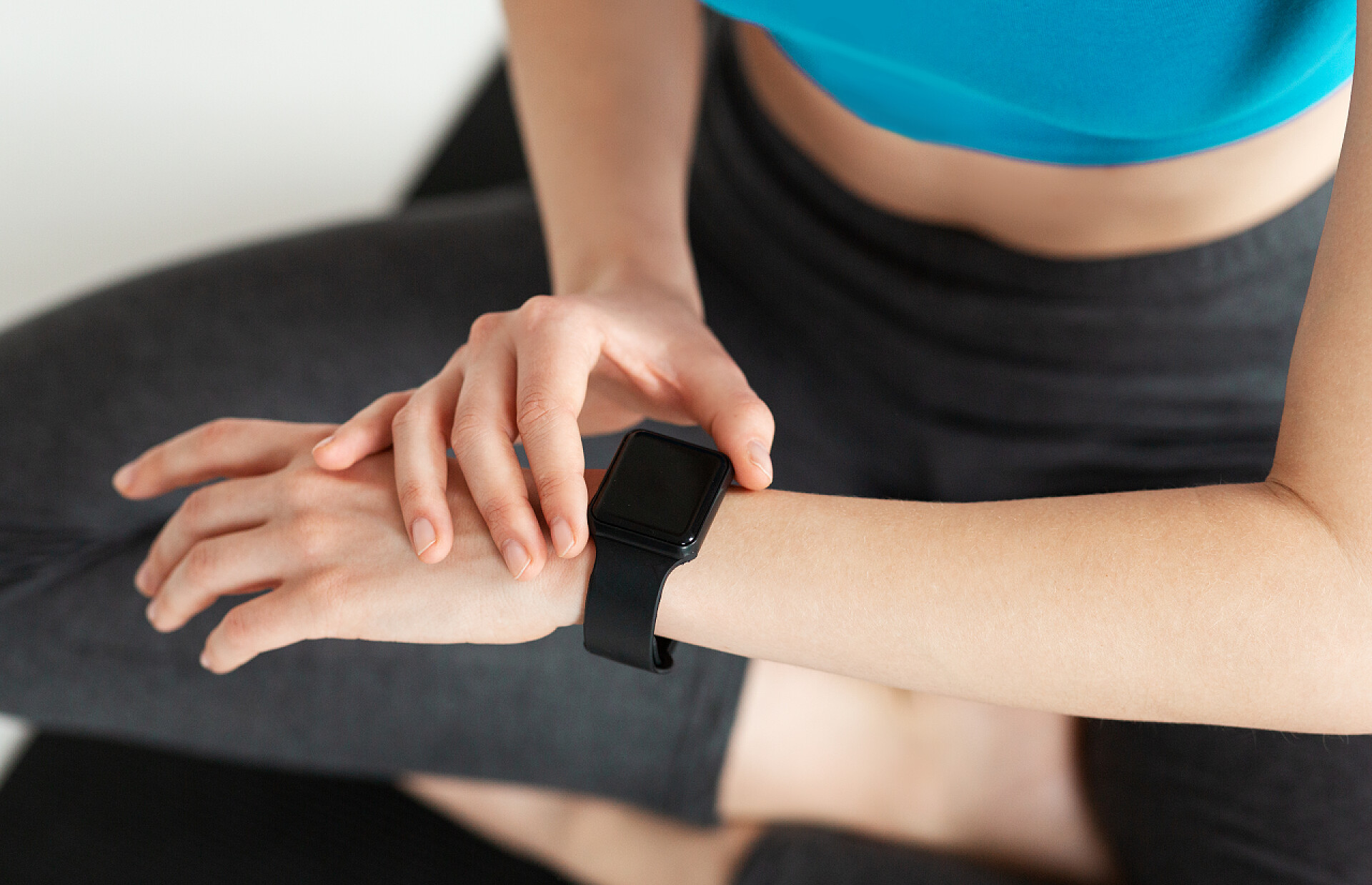 健身的女孩看手表难以辨认的年轻女运动员在训练时检查她的手表。设备屏幕上的空空间