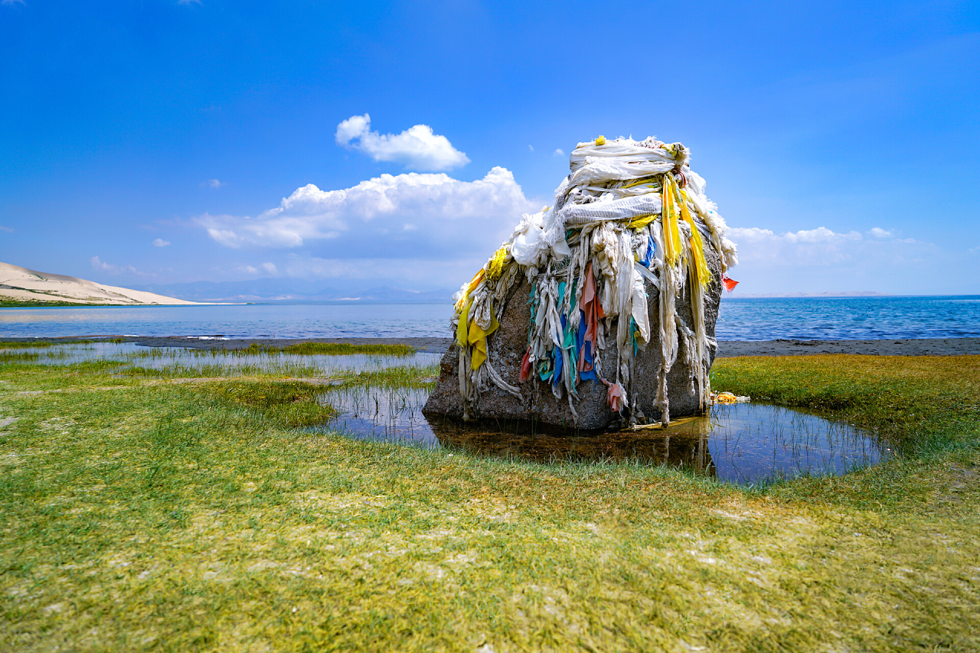 青海省青海湖沙洲的风景中国青海省青海湖的沙洲环绕着哈达石碑。沙漠和清澈的湖泊