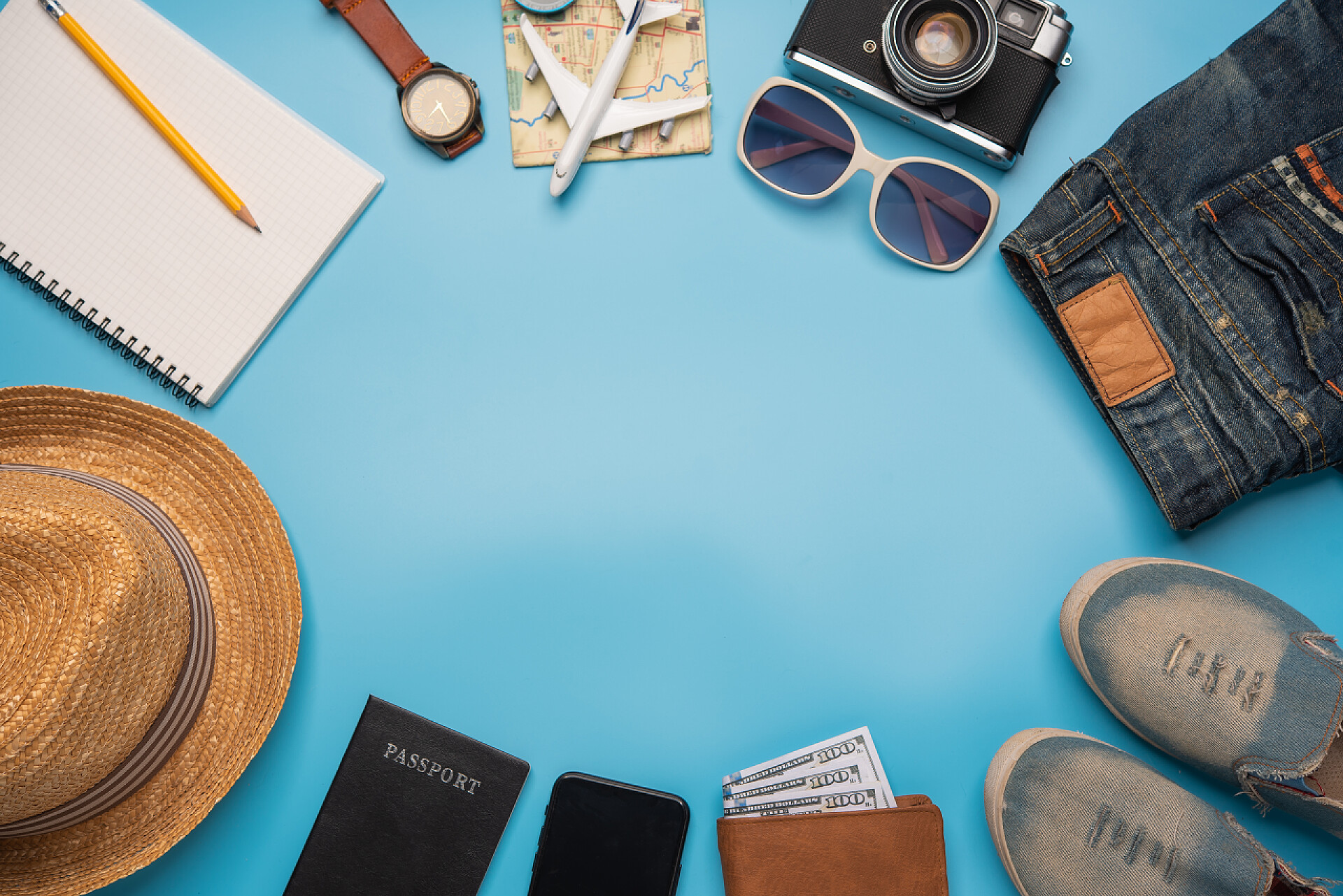 蓝色背景上的旅行配饰旅行配饰服装。护照、行李、旅行所需的旅行地图费用