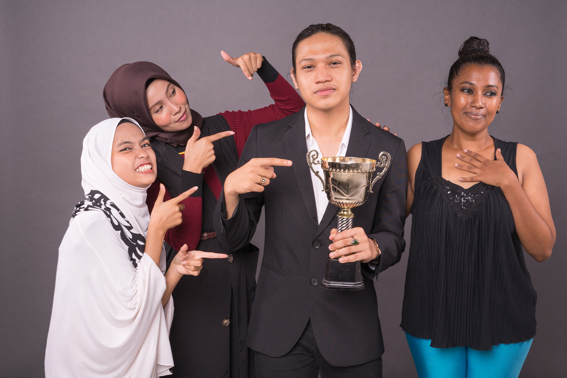 团队获得荣誉奖杯成功的团队精神庆祝活动一群专业的工作者拿着一个金杯庆祝他们的胜利.