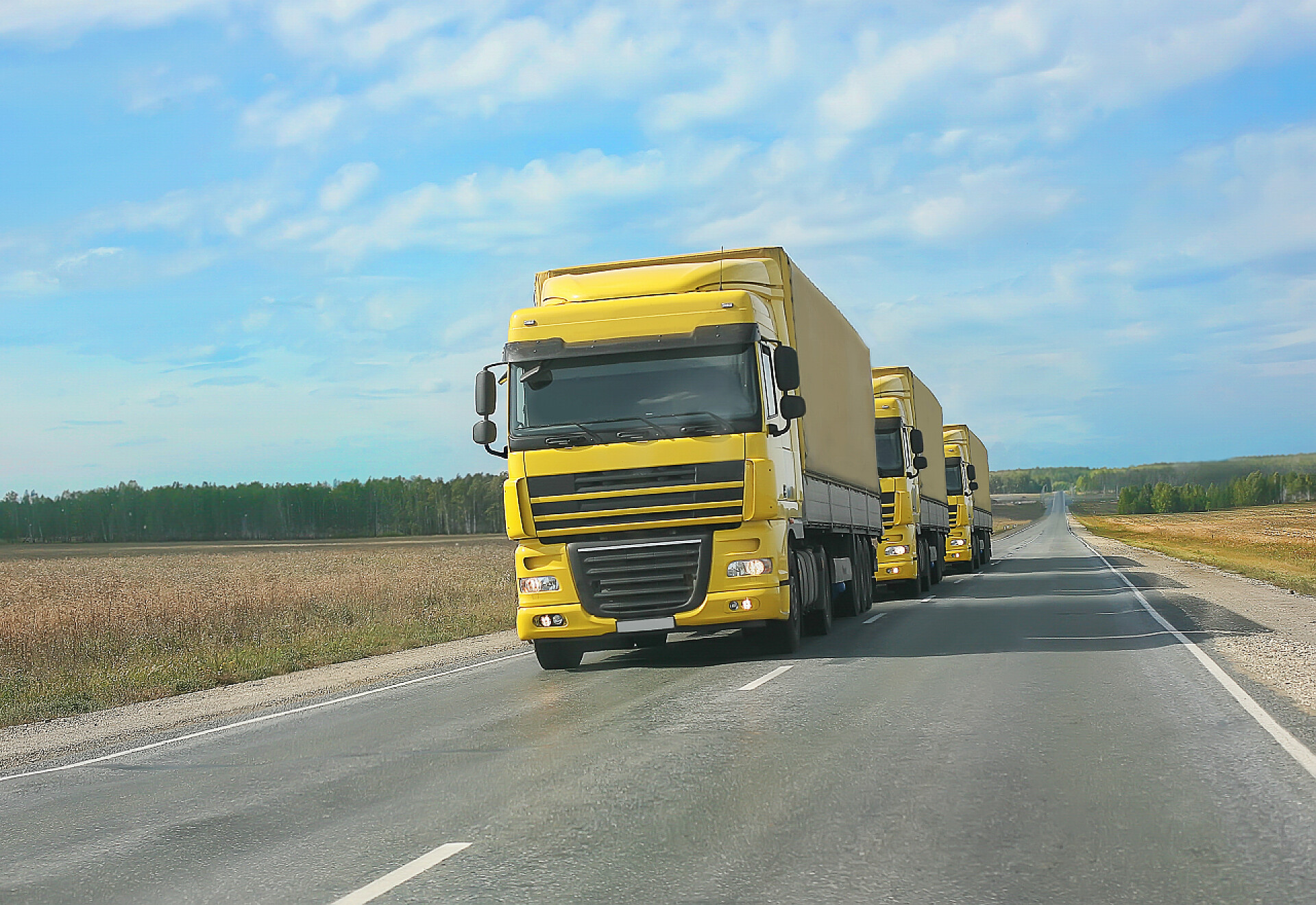 道路上行驶的黄色货车由黄色货车护送至乡村道路