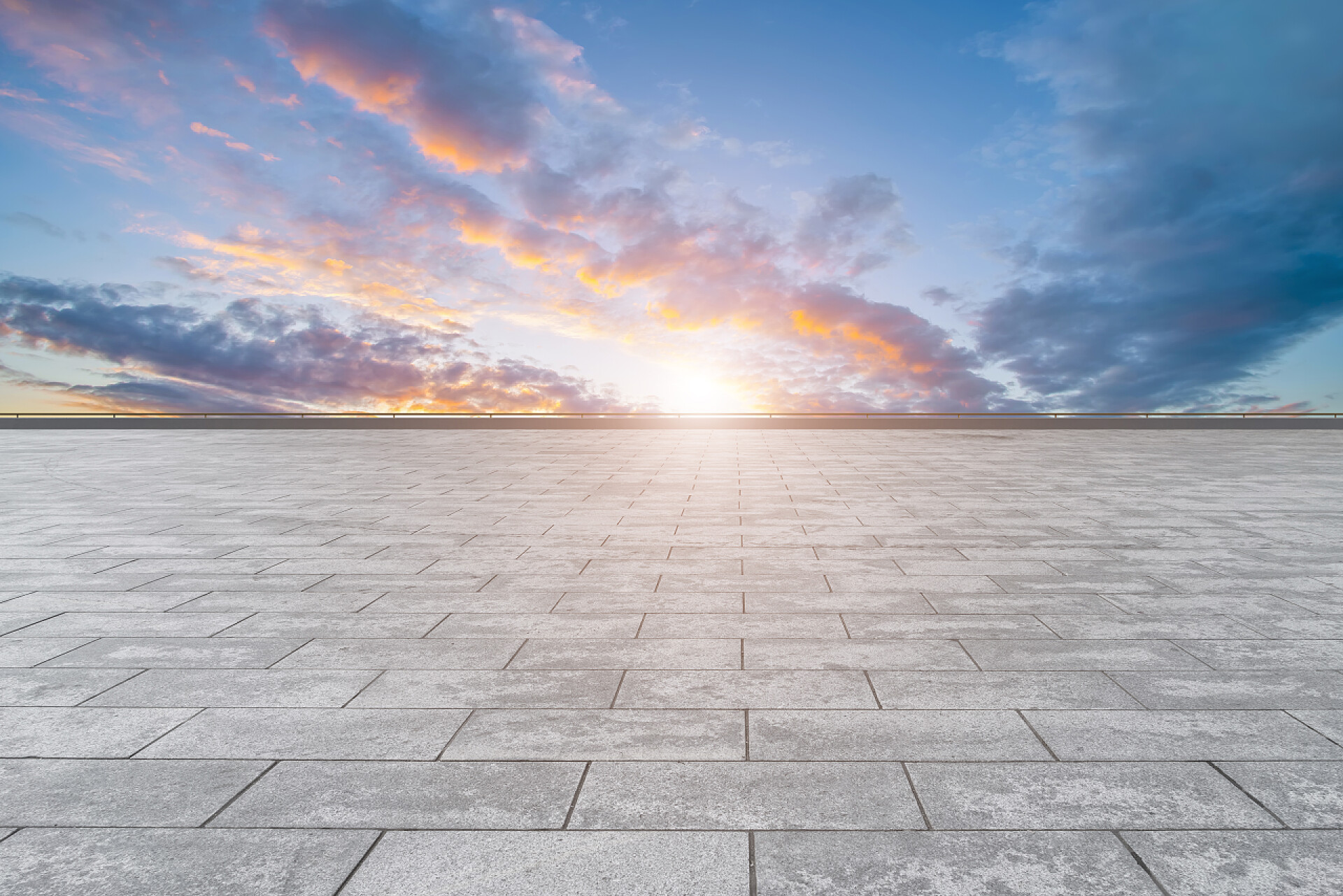 日落时分空旷的地面蓝天下空旷的大理石地板和城市景观