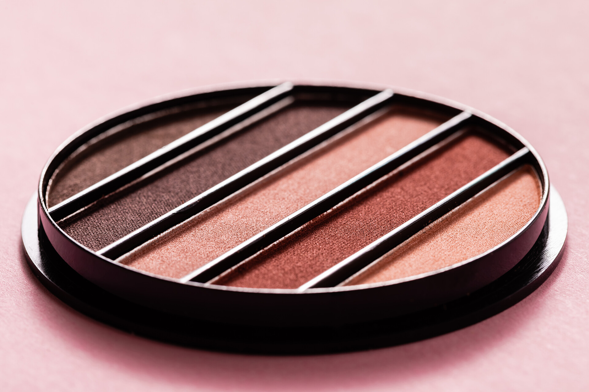 粉色背景上的眼影盘粉色上彩色眼影调色板的选择性焦点