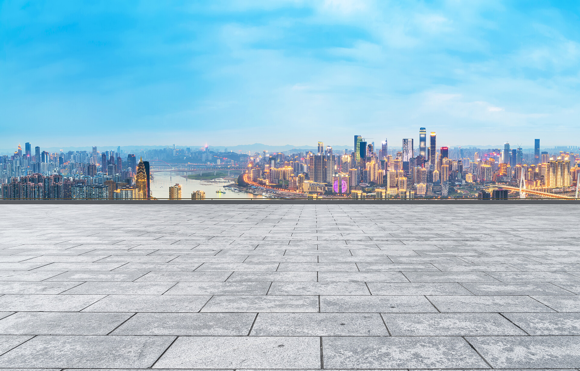 蓝天白云下空旷的地面和远处的建筑城市摩天大楼和正方形的石板地面