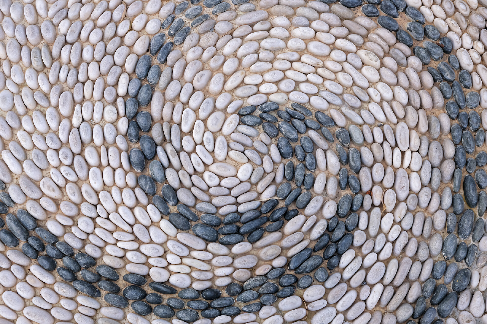 铺在路上的鹅卵石.旧鹅卵石路背光低的背景图片。石材质地紧密相连.路上的小鹅卵石石路带有复制空间的横幅.