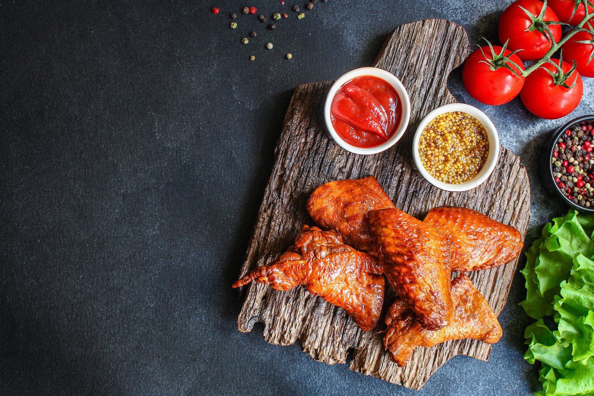 黑色背景上美味的烤鸡腿和新鲜的蔬菜炸鸡翅熏肉烧烤菜单概念服务的大小。食物背景顶视图复制空间为文本有机健康饮食