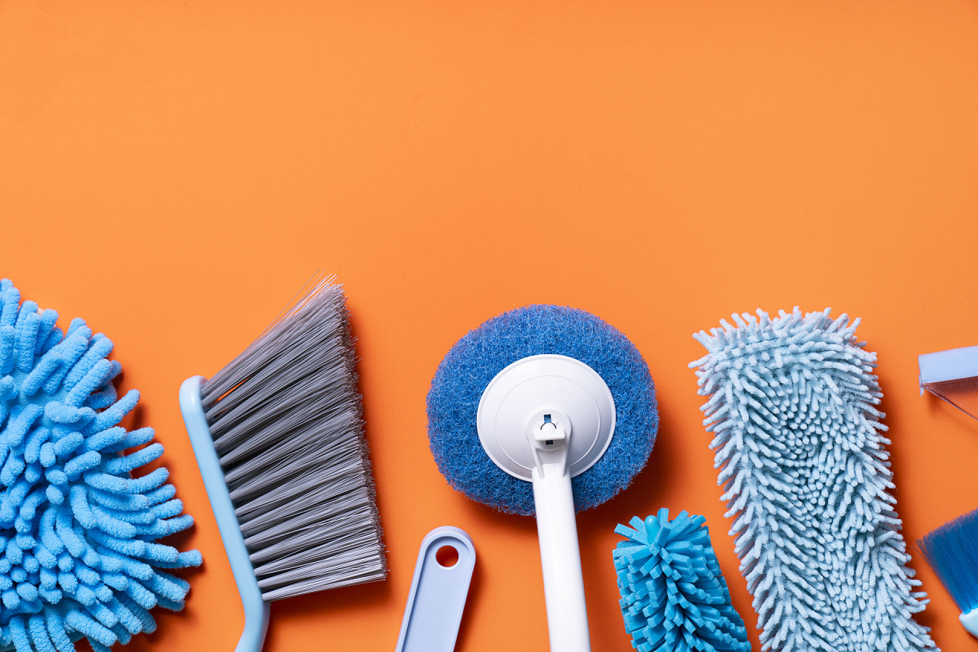 橙黄色背景上的清洁工具橙色桌子背景上的家庭清洁产品设备