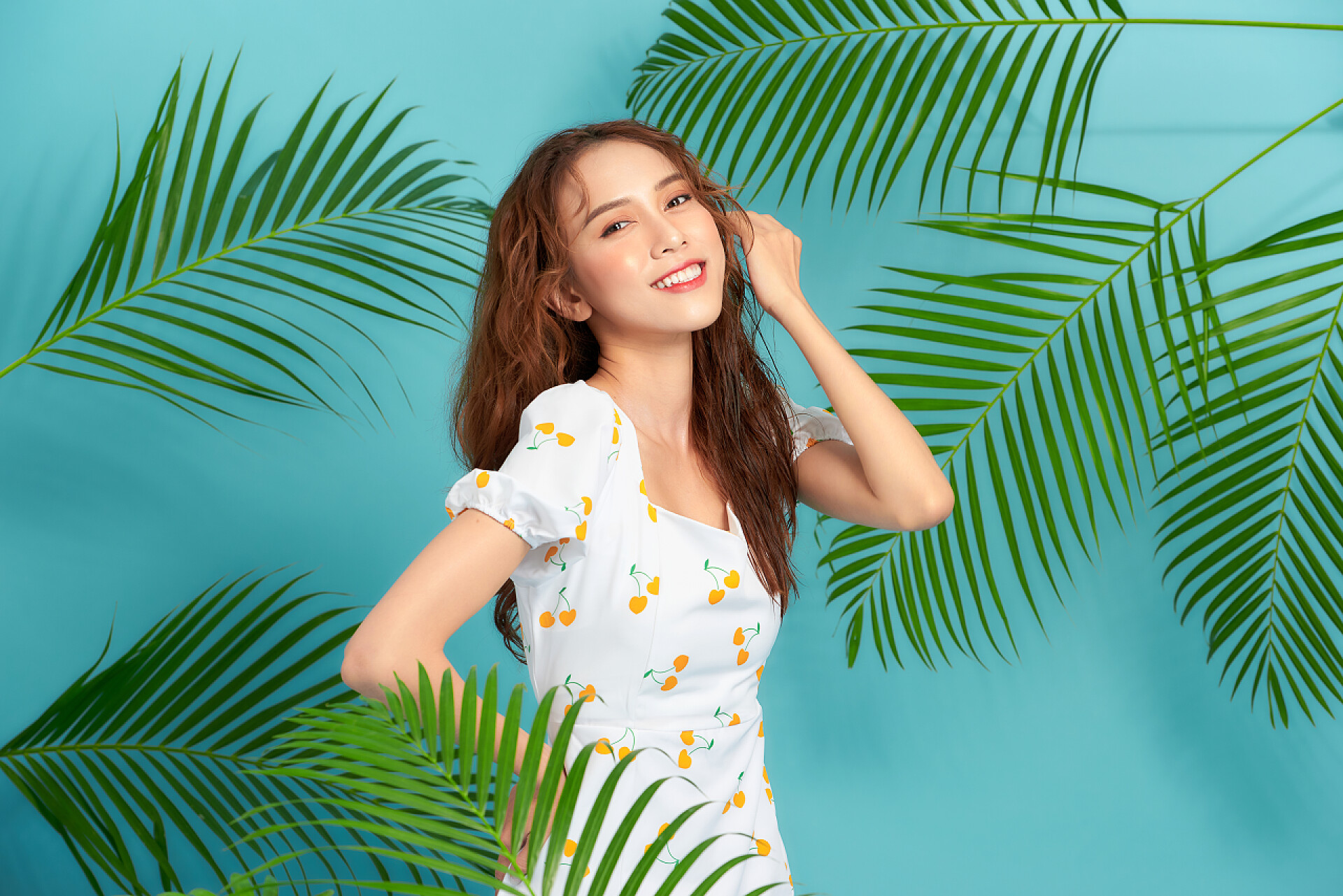 蓝色背景上微笑的亚洲女孩年轻美丽的亚洲女人，皮肤健康，底色鲜艳