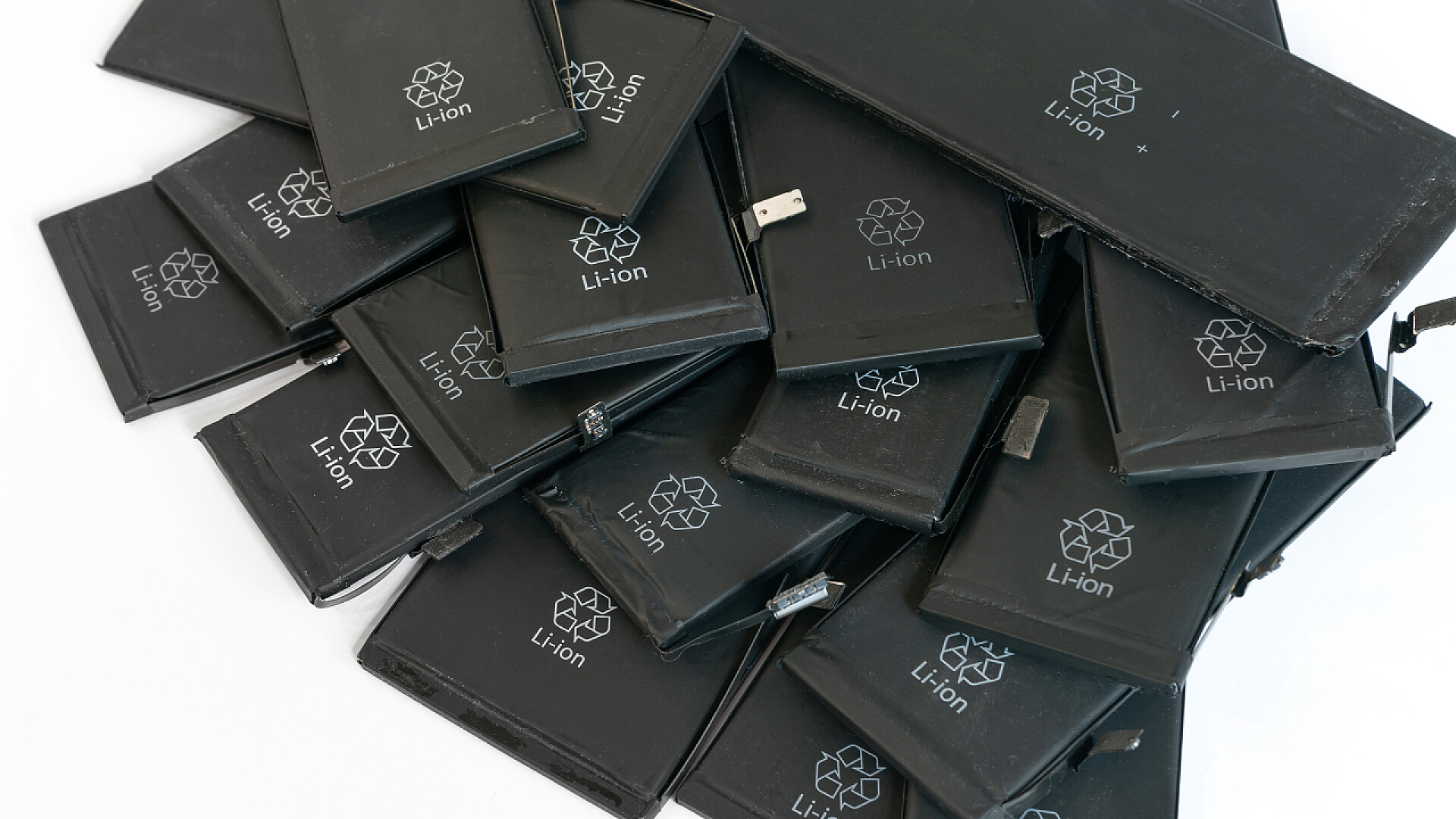 白色背景上回收的移动电话锂离子聚合物电池关闭用过的移动电话锂离子聚合物电池，为回收利用作准备。复制空间