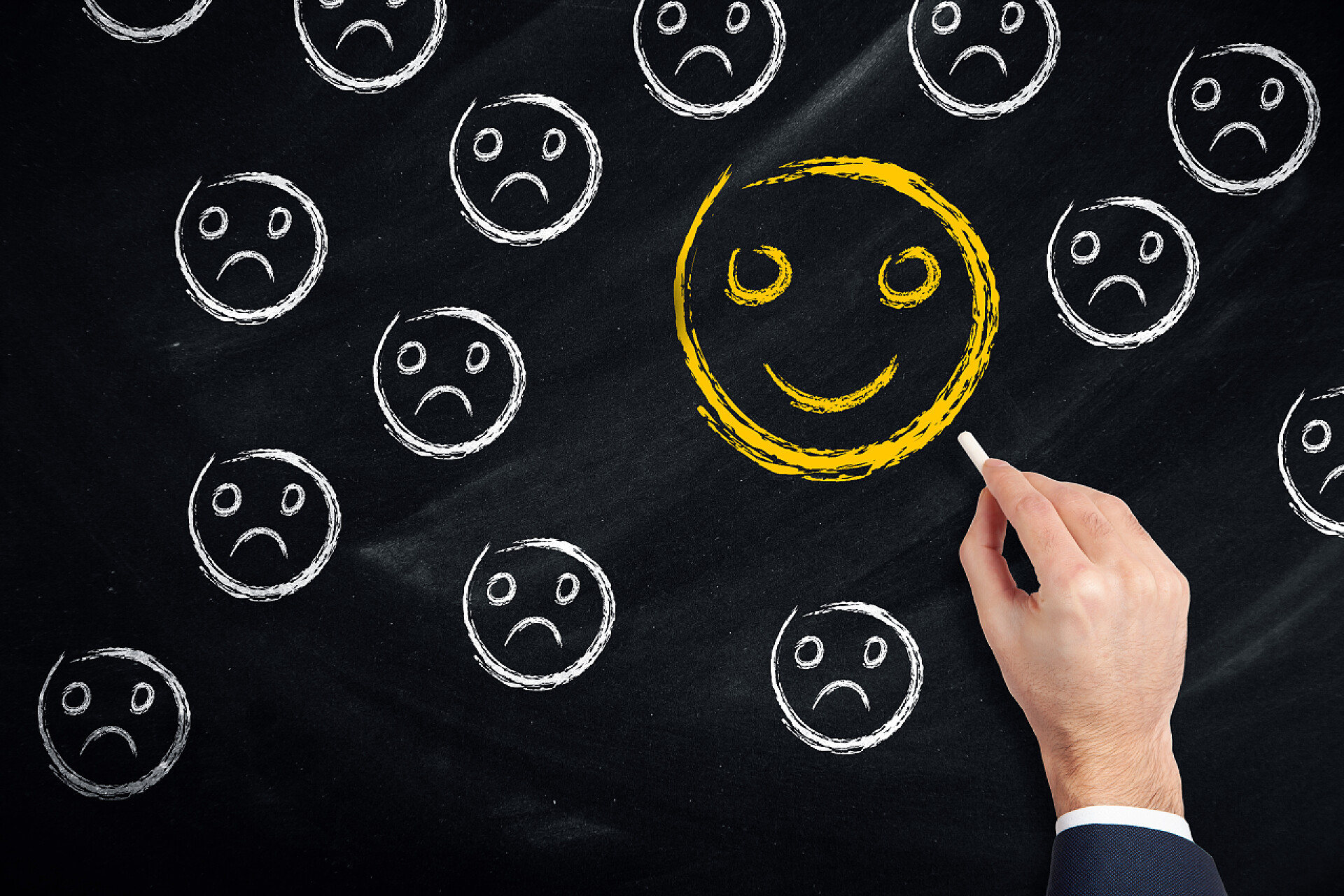 黑板上手绘的悲伤与快乐的脸谱特写黑板上的悲伤与快乐的脸谱