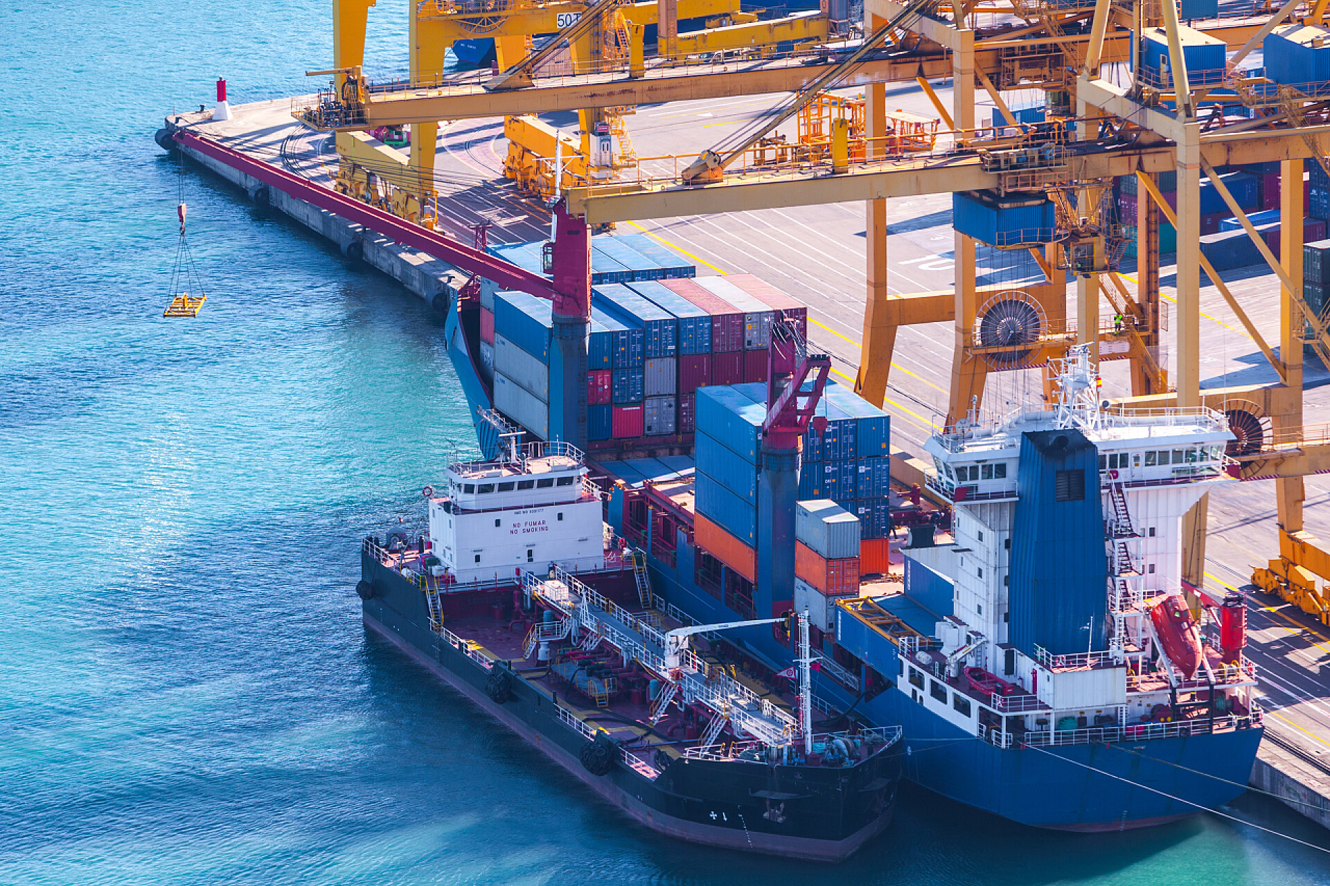 港口边的船只在海港集装箱码头的海运船用集装箱起重机上装卸