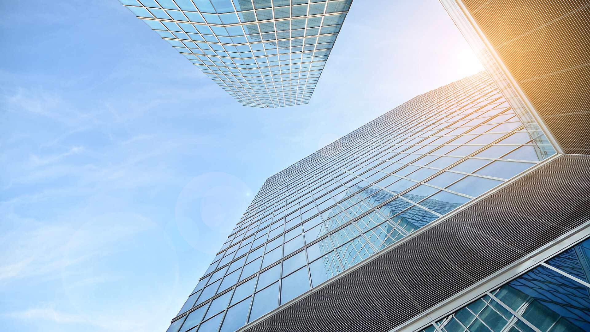 仰视蓝天下的商业大楼摩天大楼玻璃轮廓的最底层视图.商业大楼。有玻璃立面的摩天大楼。商业区的现代建筑。经济、金融、未来的概念.   