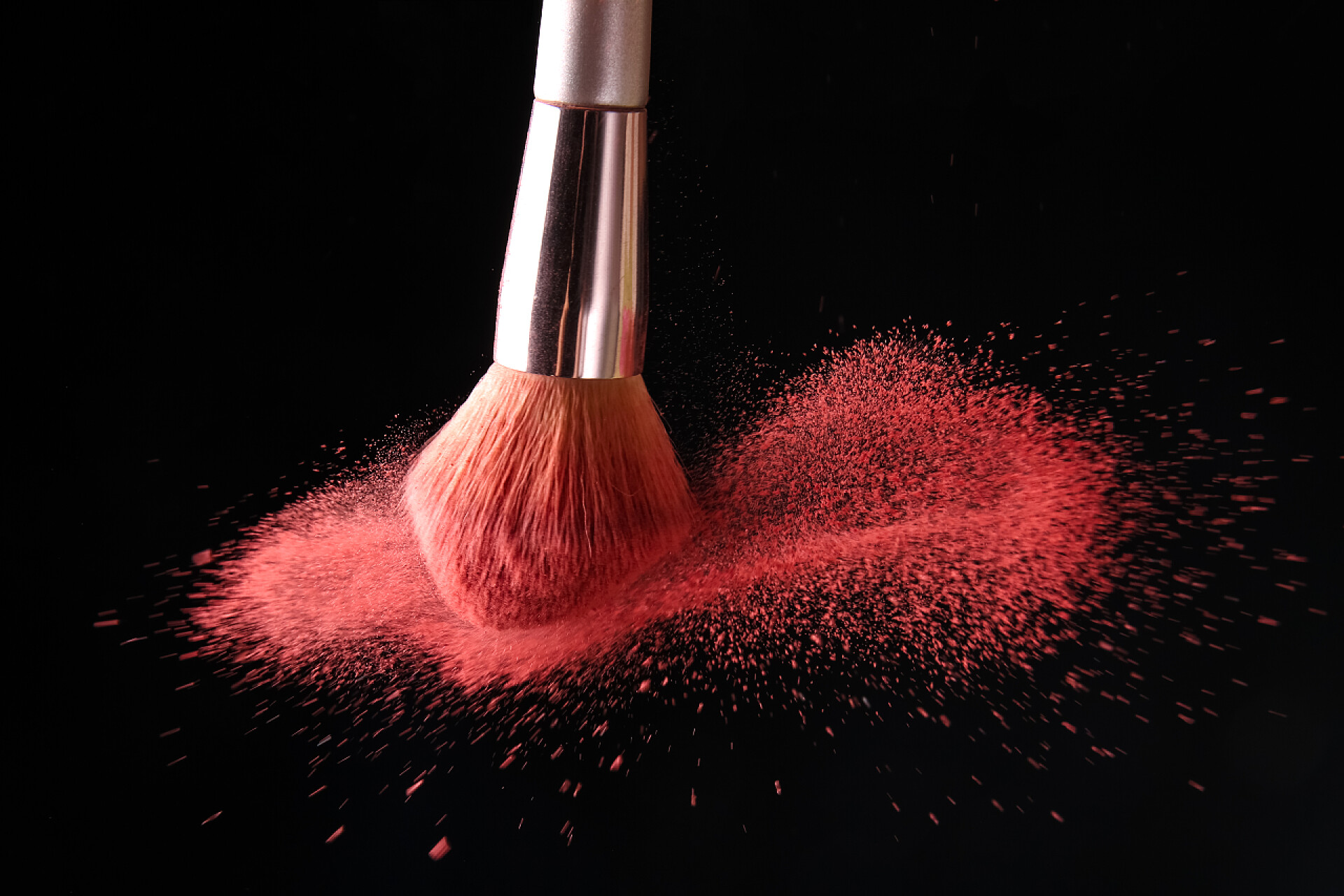 黑色桌子上的化妆刷和粉末深色底色的化妆刷和化妆品碎屑