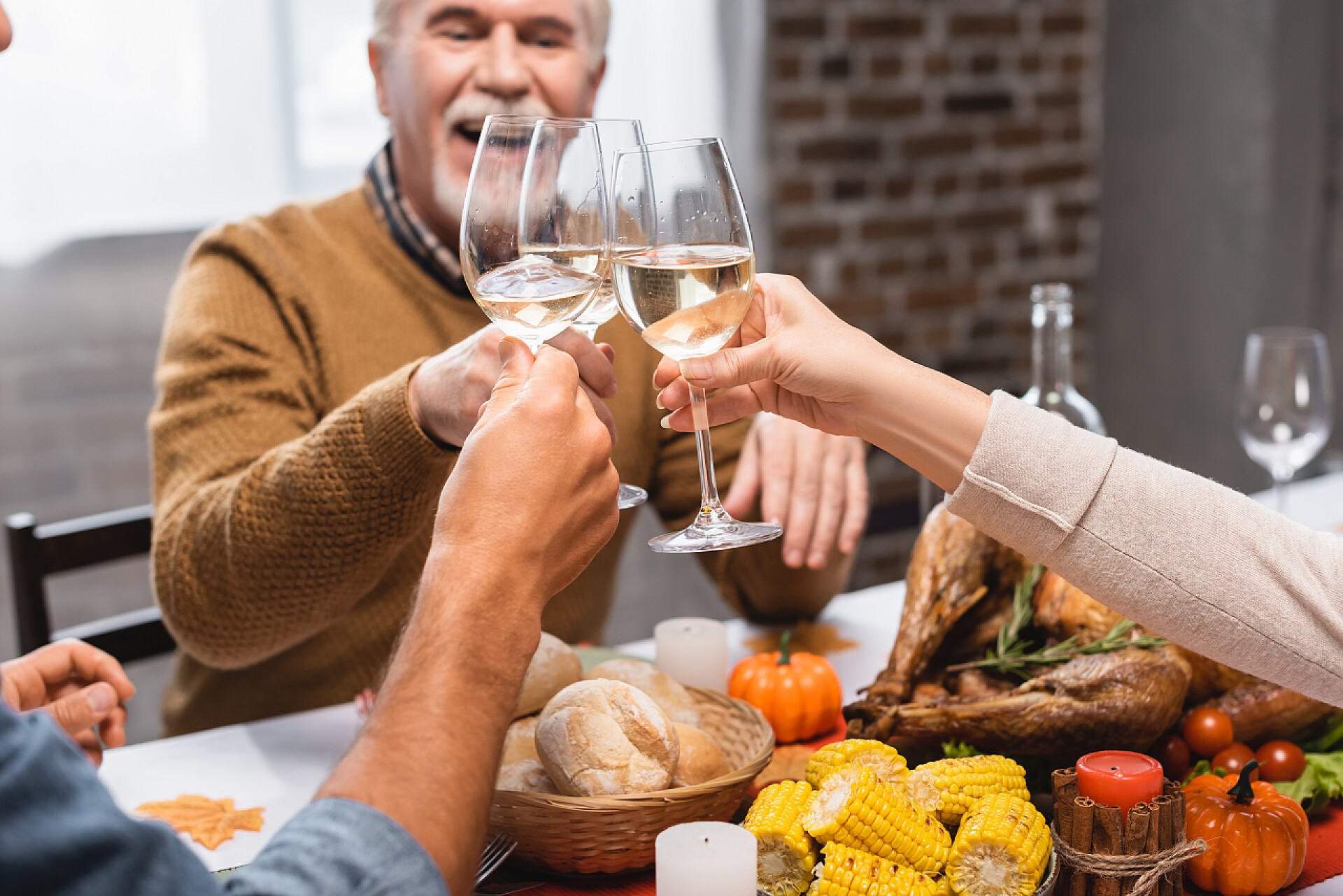 在一起去喝白葡萄酒的家人感恩节大餐期间，一家人在酒杯中碰杯白葡萄酒