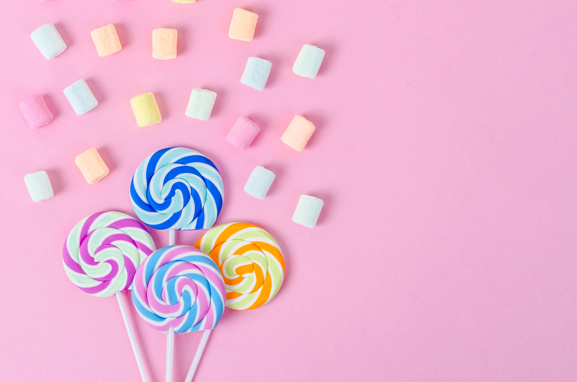 粉色背景前的糖果色彩艳丽的棉花糖，粉红背景的糖果.
