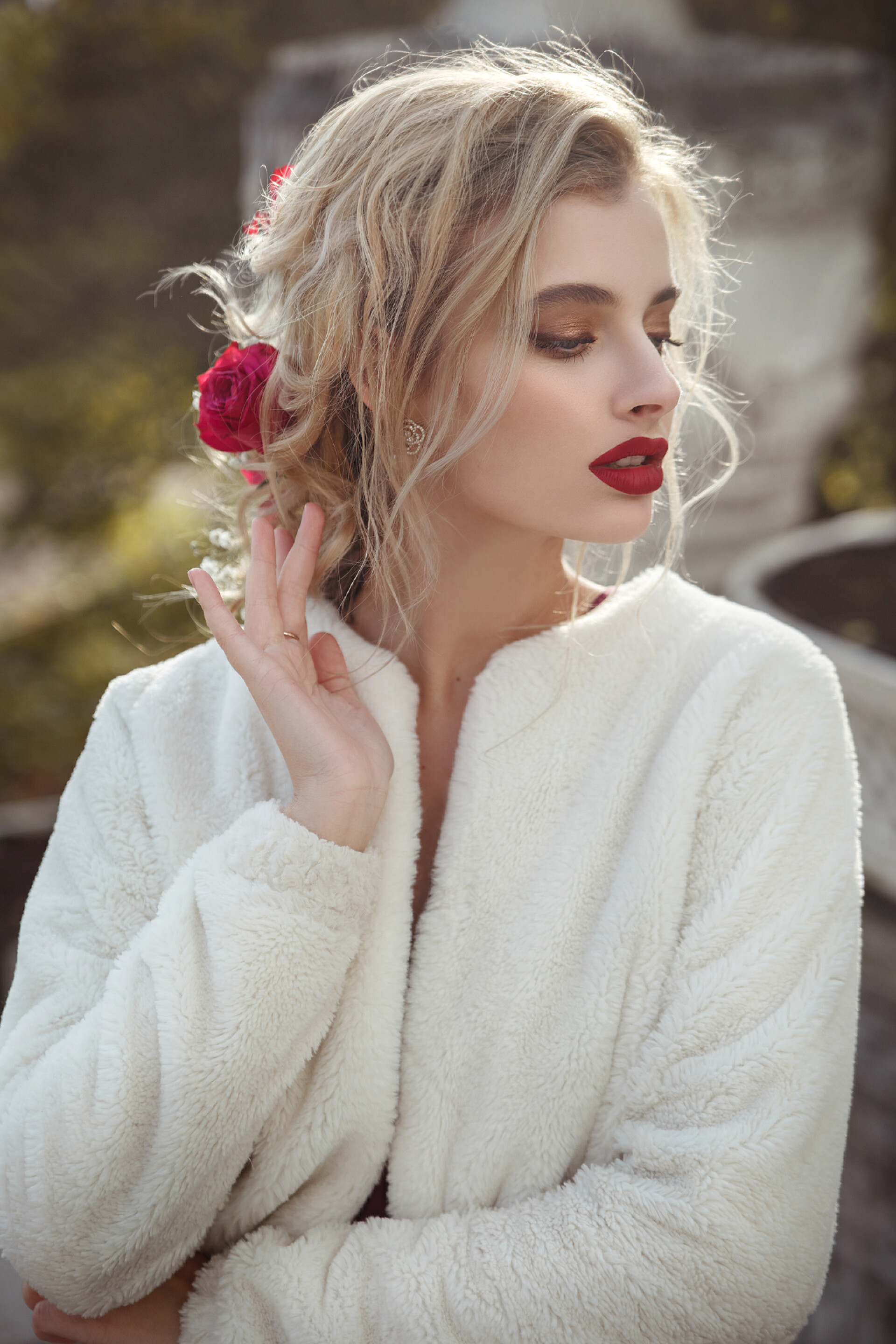 一个美丽的女人在拍照在一个阳光灿烂的日子里，在一个秋天的公园里，一个美丽的新娘带着淡淡的雅致的发型和夜晚的妆容，她的画像.