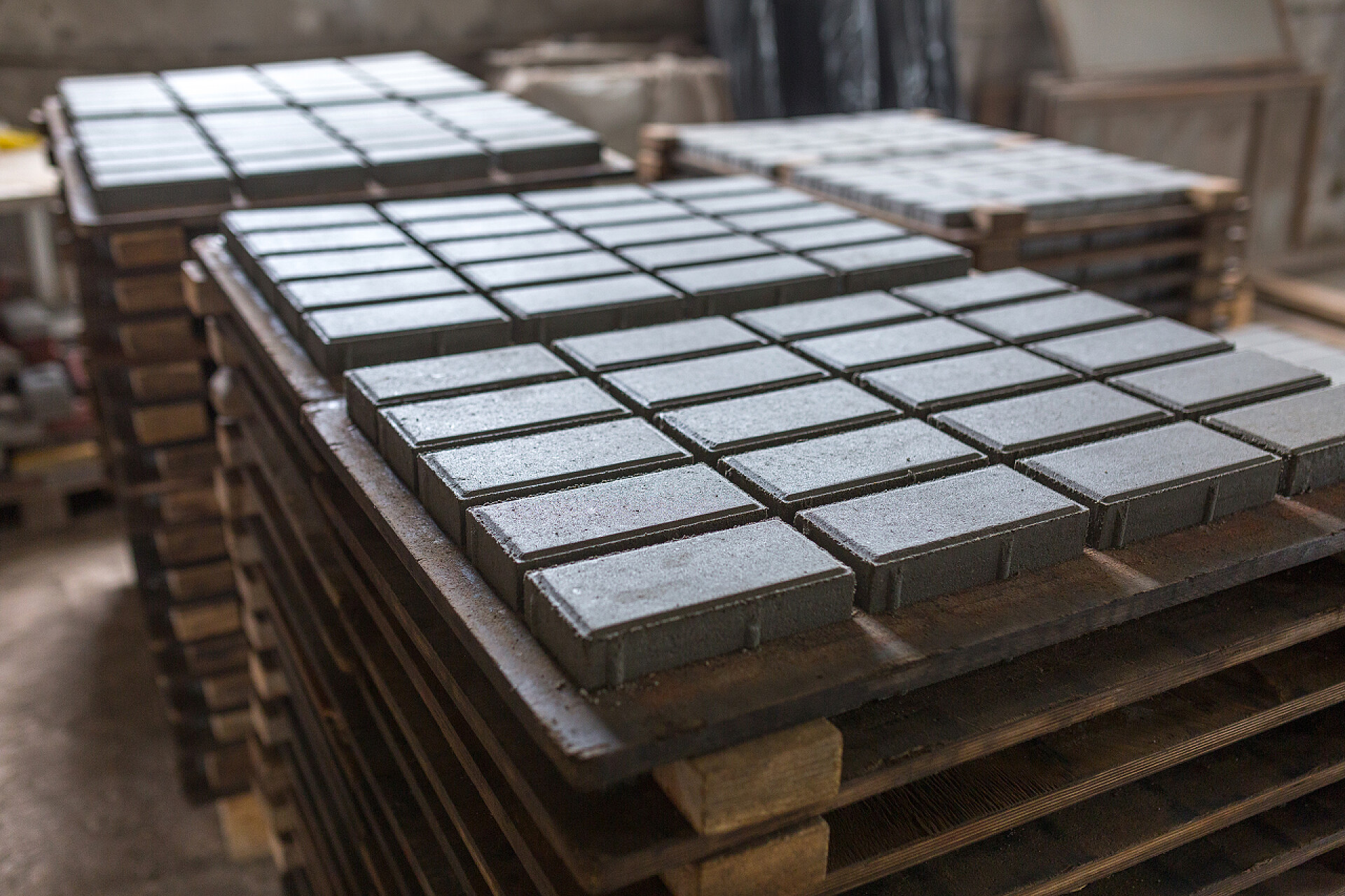 在建造工厂被压实的水泥块用压实水泥砂浆进行建筑材料工业生产.优质水泥制成的优质铺路石。压印后，成品堆放在干燥无味的货盘上.