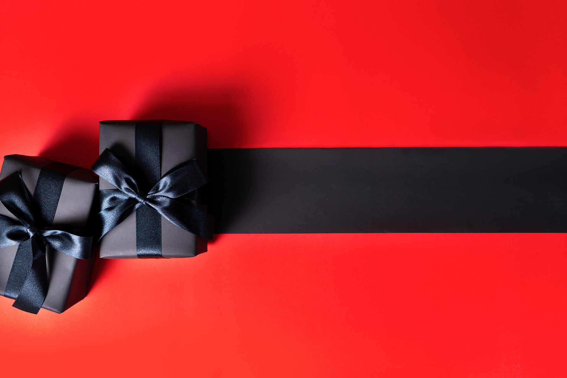 红色桌子上的黑色礼盒和黑色线条黑色星期五甩卖，网上购物用黑色礼品盒
