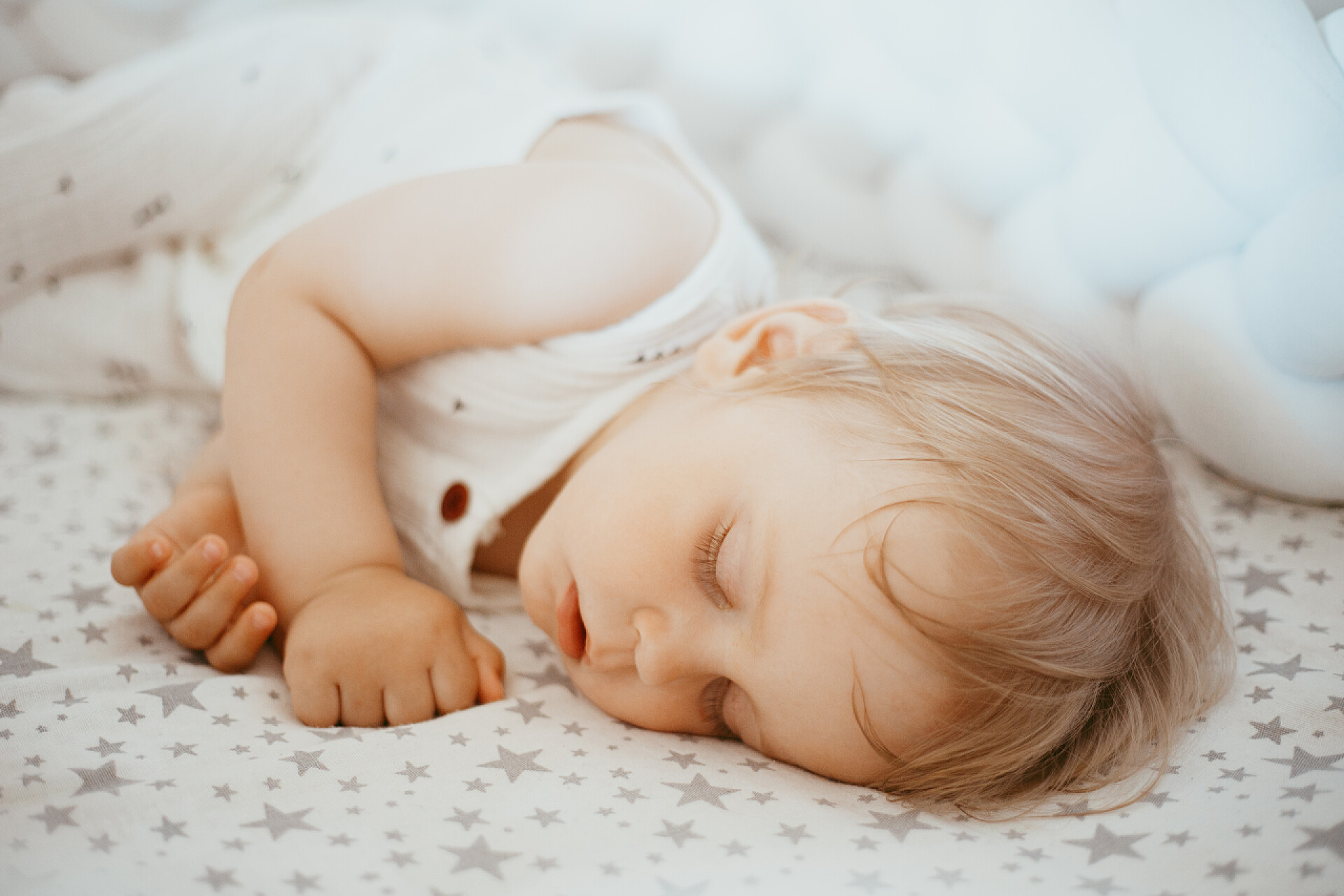 一个小孩子侧卧睡着在床上睡觉的可爱男婴的特写，一岁大的婴儿概念