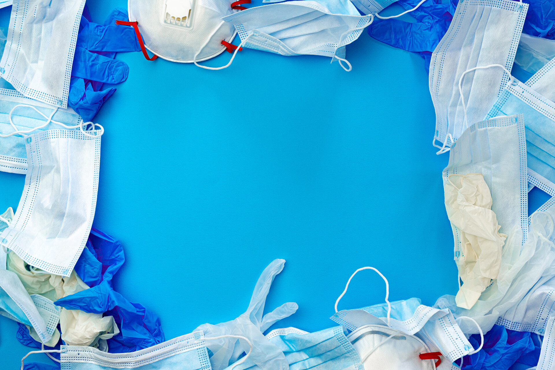 蓝色桌子上的医用废品蓝色背景的防护设备、面具和手套