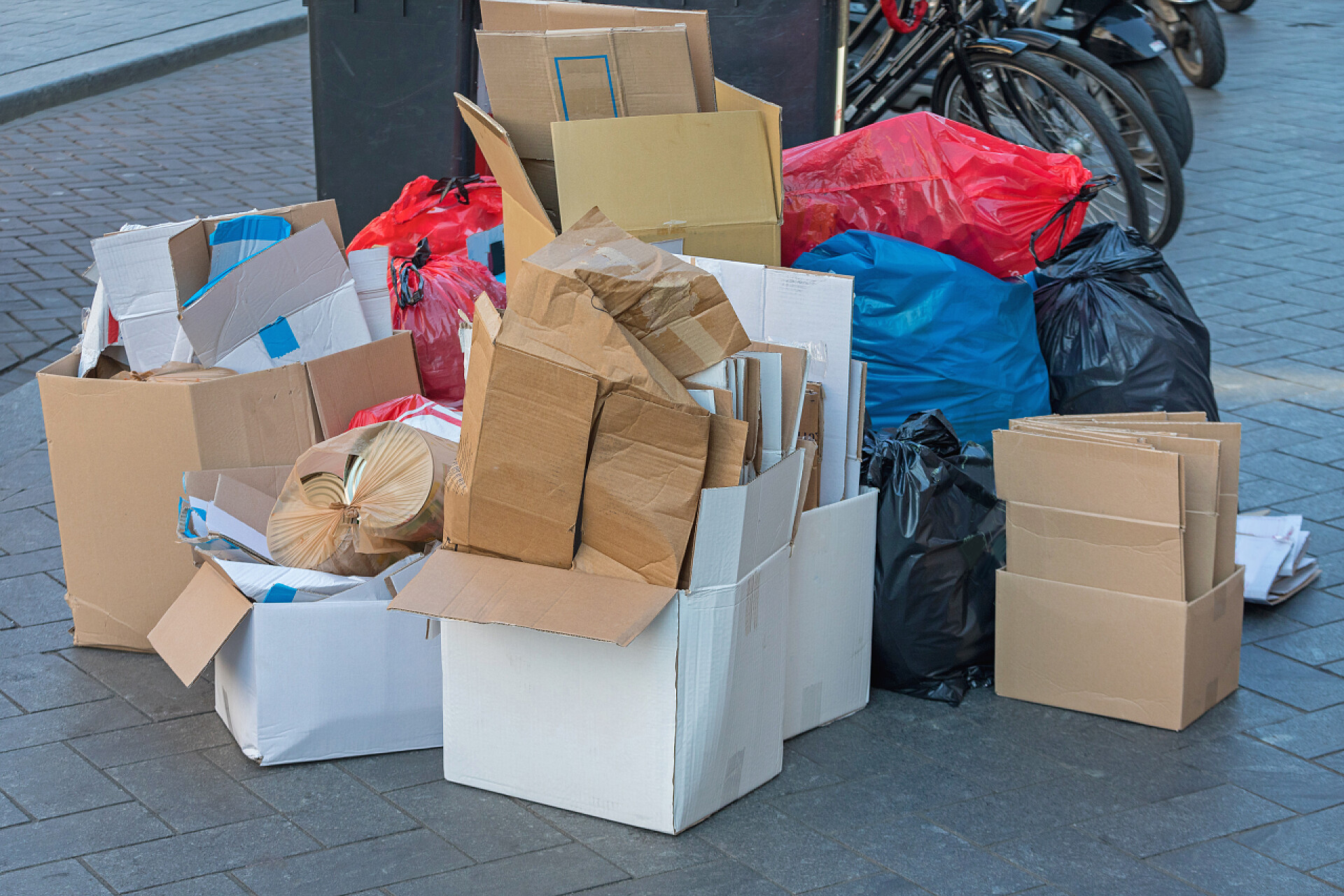 垃圾桶旁边的纸箱和垃圾袋街上的纸板箱及垃圾袋