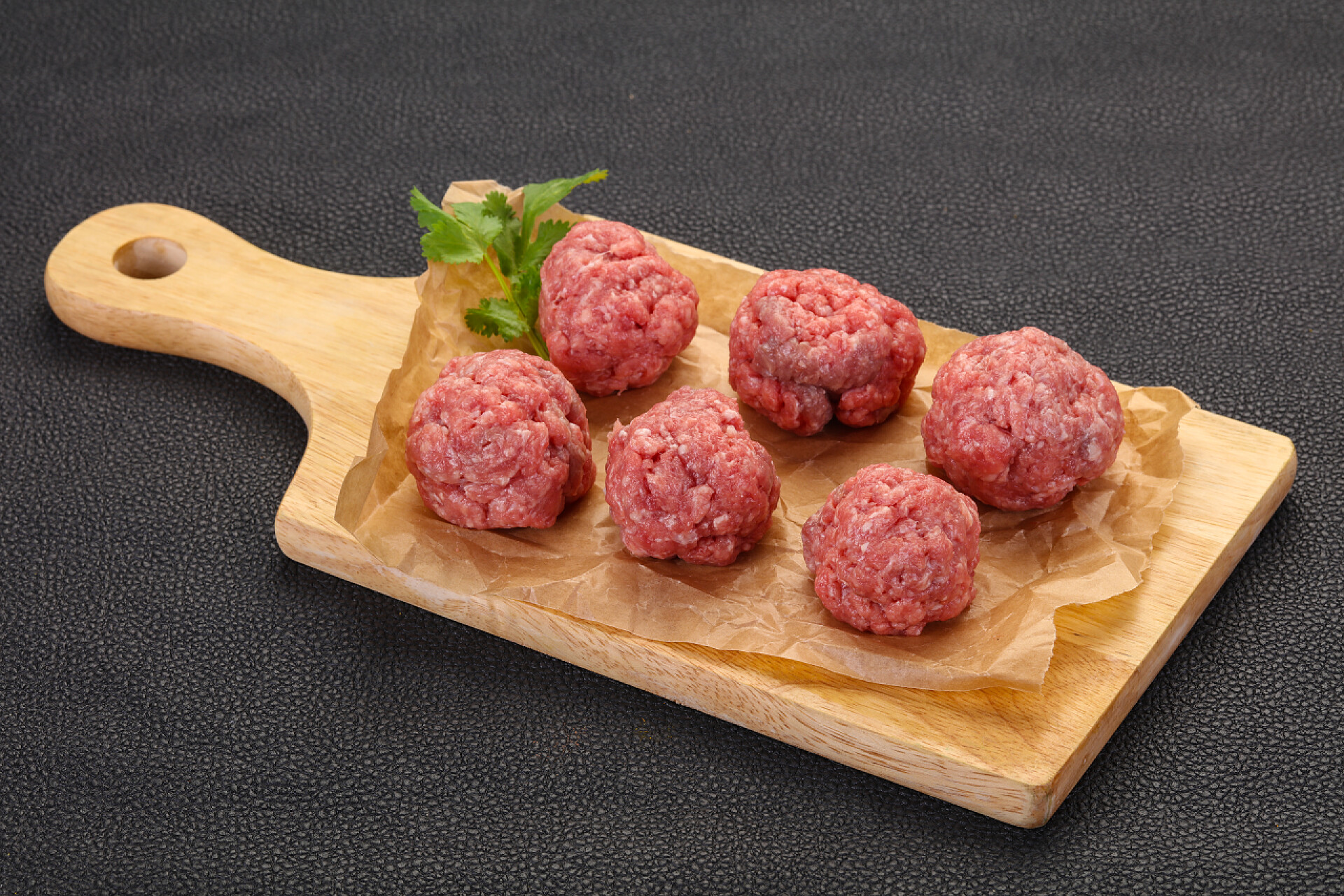 菜板上的六个肉丸生肉丸子盖在木制背景上准备烹调