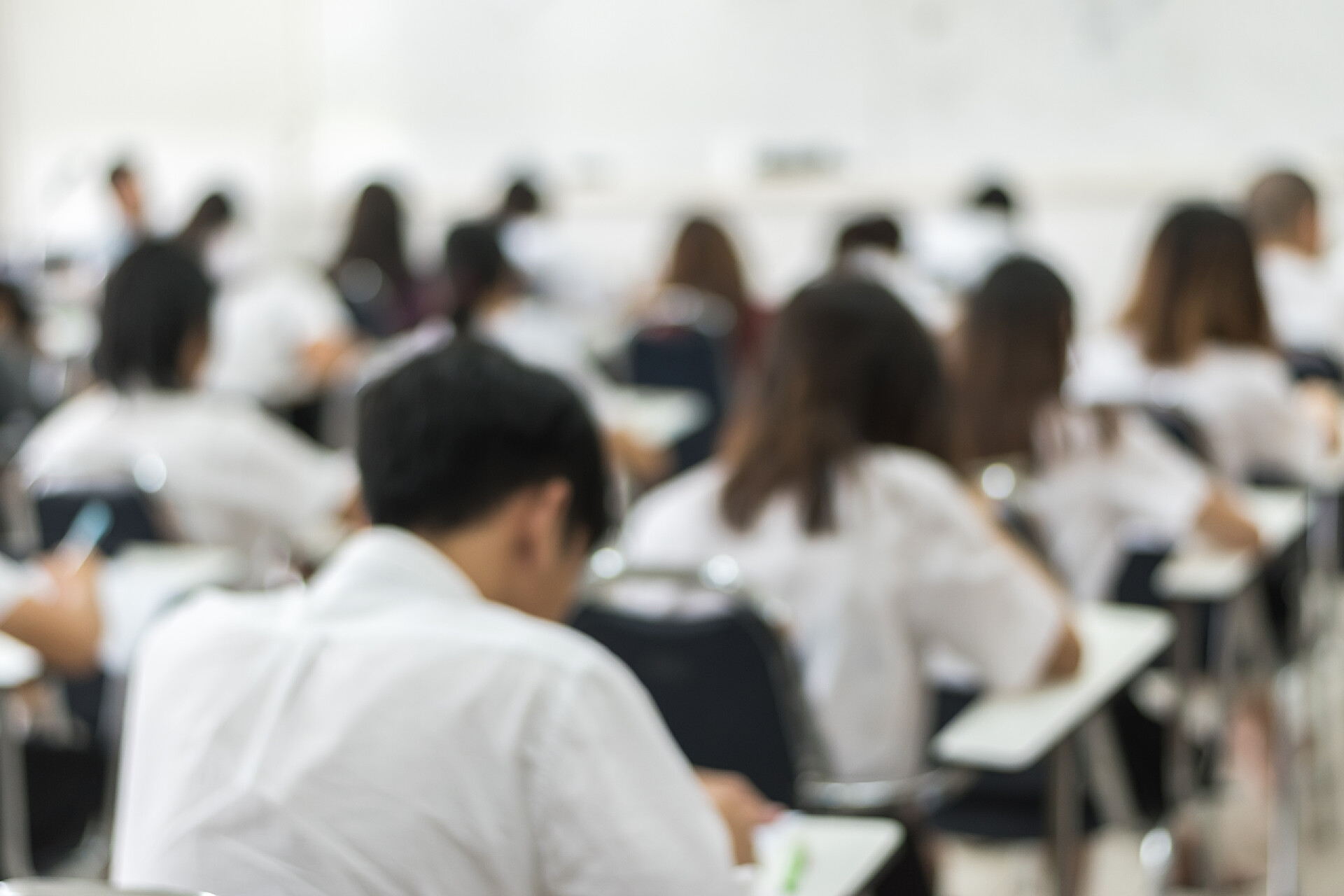 模糊的学校背景大学生在上课模糊的学校背景大学生在课堂上写答题