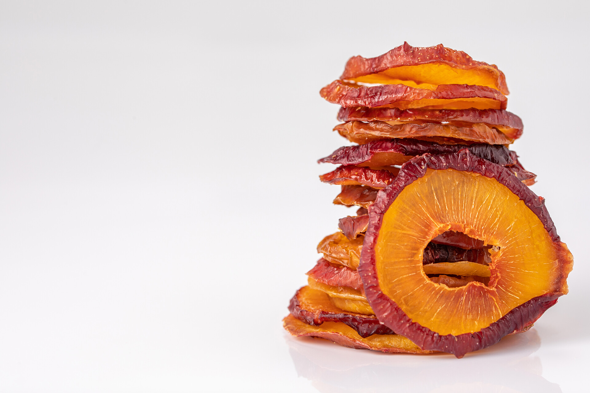 白色背景前的李子干白底上的干李子片。干果。生态。宏观。雅致.