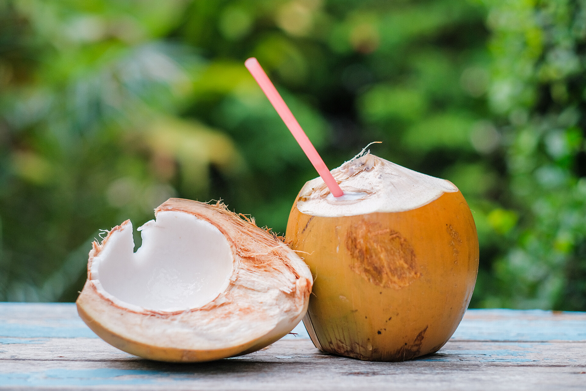 桌子上的椰子年轻的椰子，有稻草可以饮用