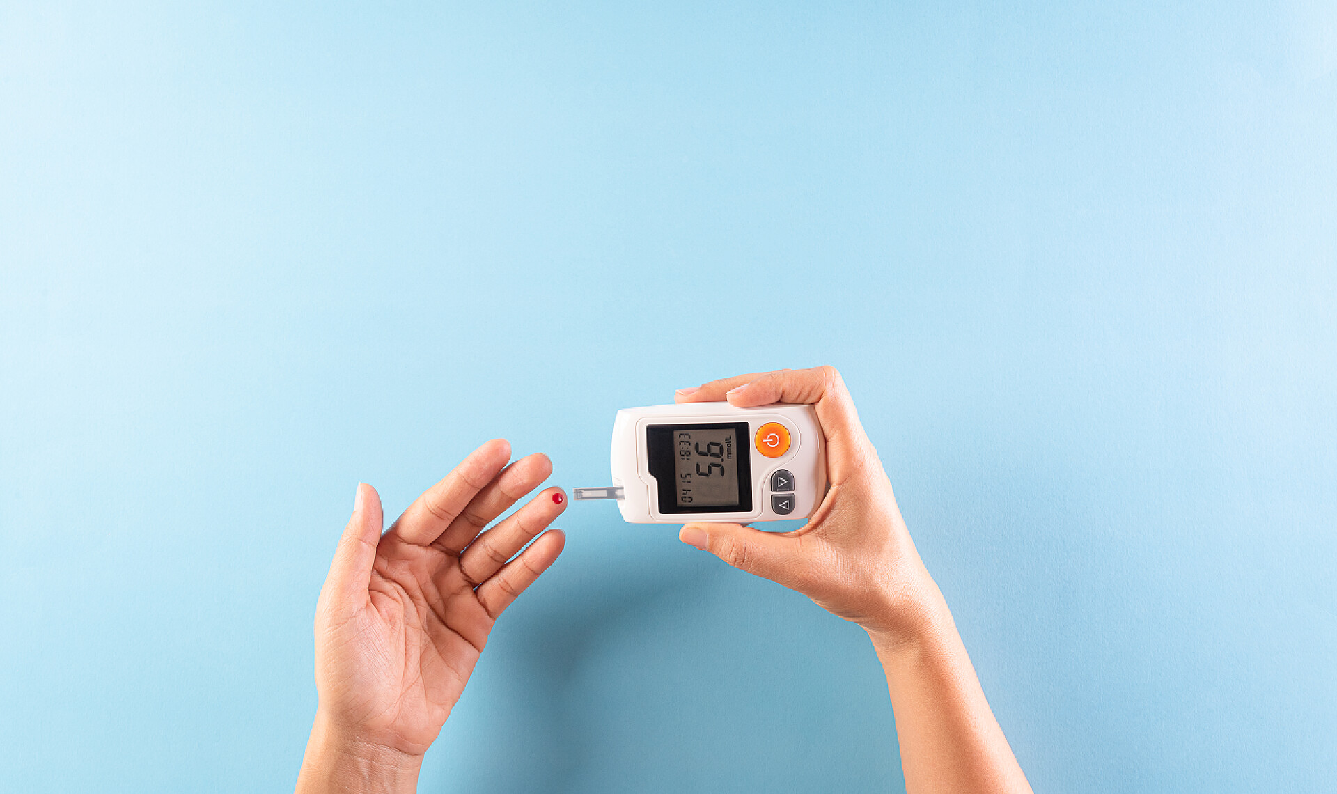 蓝色背景下测试血糖的人世界糖尿病日意识概念。糖尿病测量血液中的葡萄糖含量，11月14日.