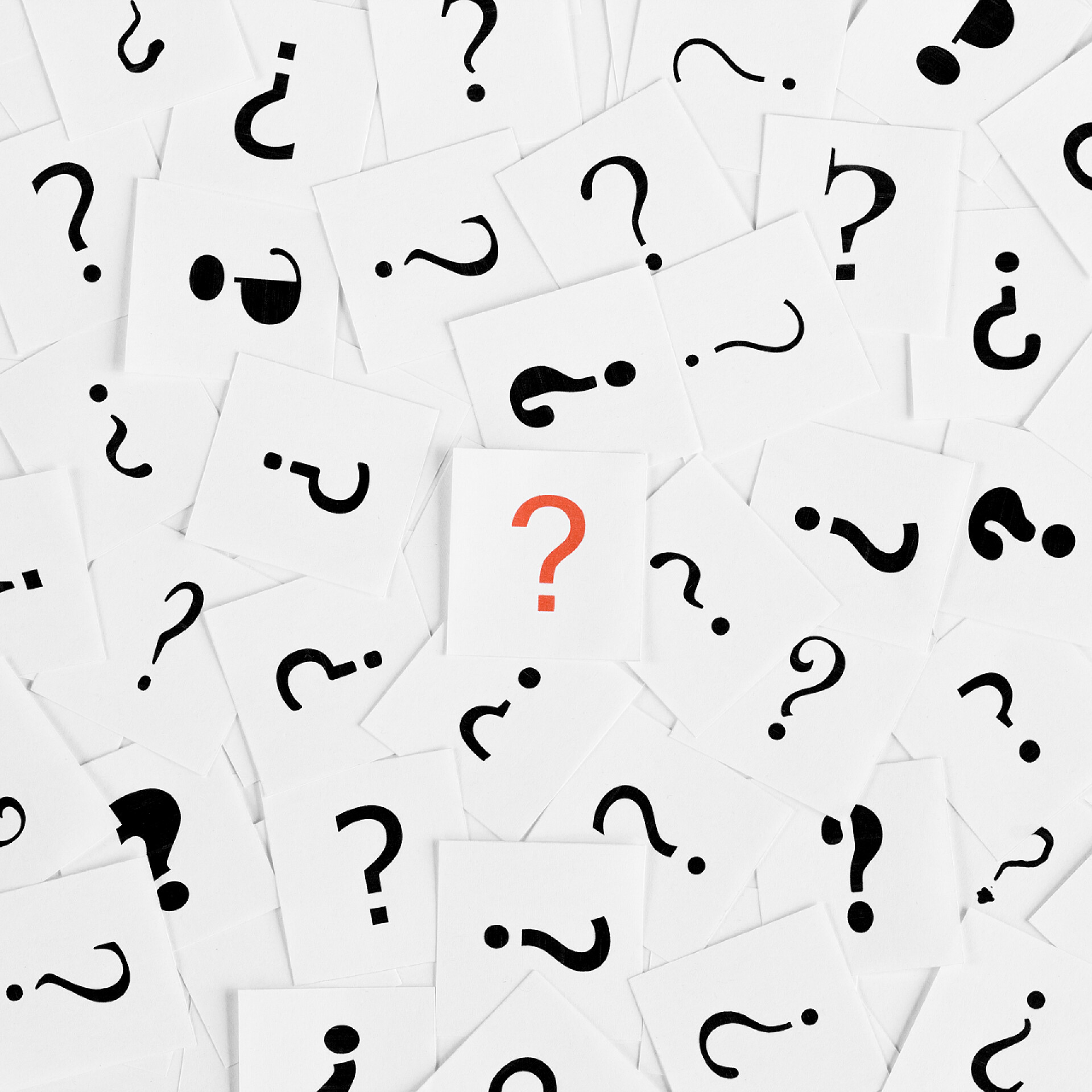白纸上的问号一堆问号到处都是，中间有一个红色的符号。决定、查询或faq概念.