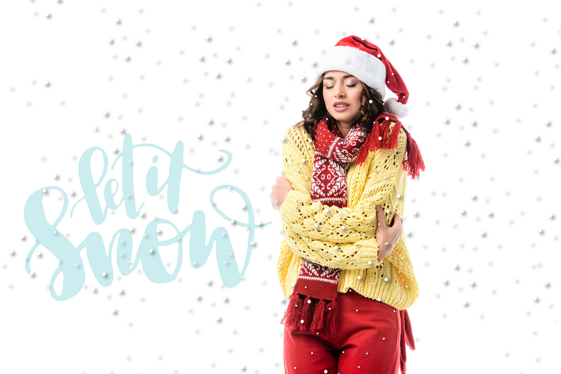 白色背景前一个戴着圣诞帽的女人站在旁边的戴着圣塔帽、戴着围巾的冰冷的年轻女子让雪在雪地上刻着白字 