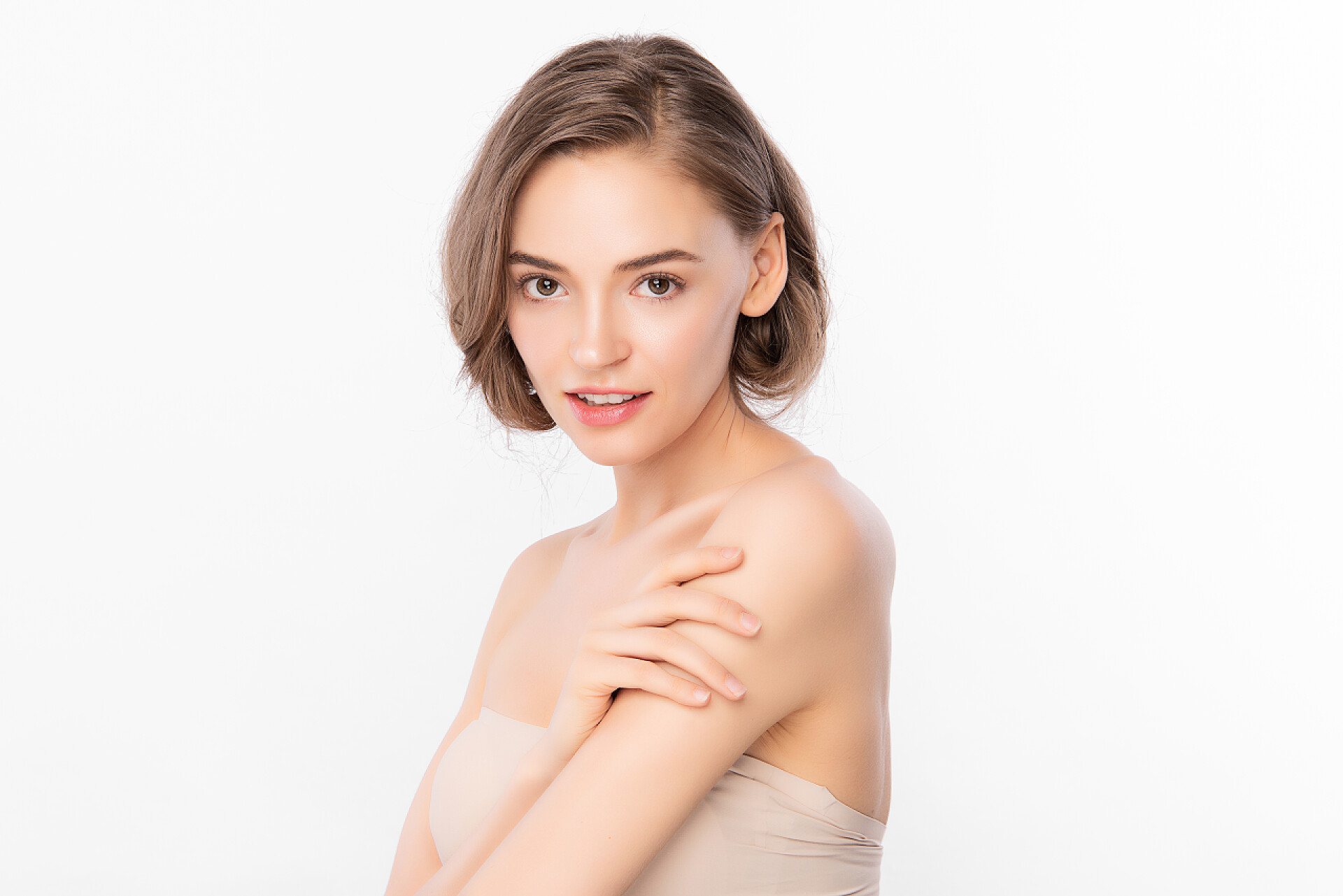 白色背景前的美女在拍照美丽的年轻女子，有着洁白的背景、脸蛋护理、面部护理、美容美发、美容美发、水疗、女性肖像等洁白的肌肤