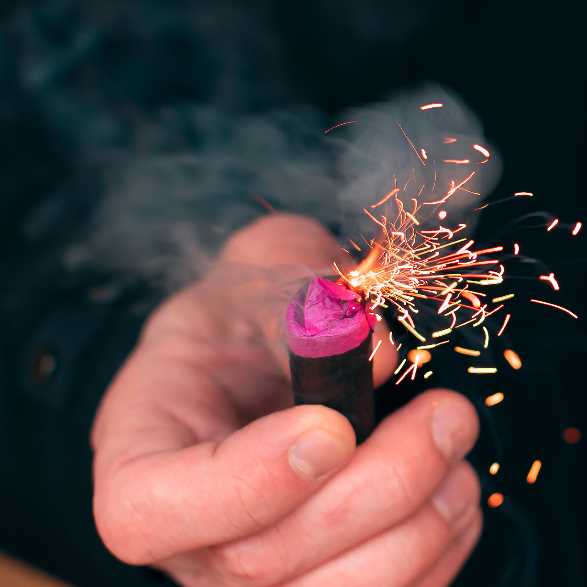 一个手拿火焰喷射器的男人火焰喷射器与火花和烟雾一起燃烧