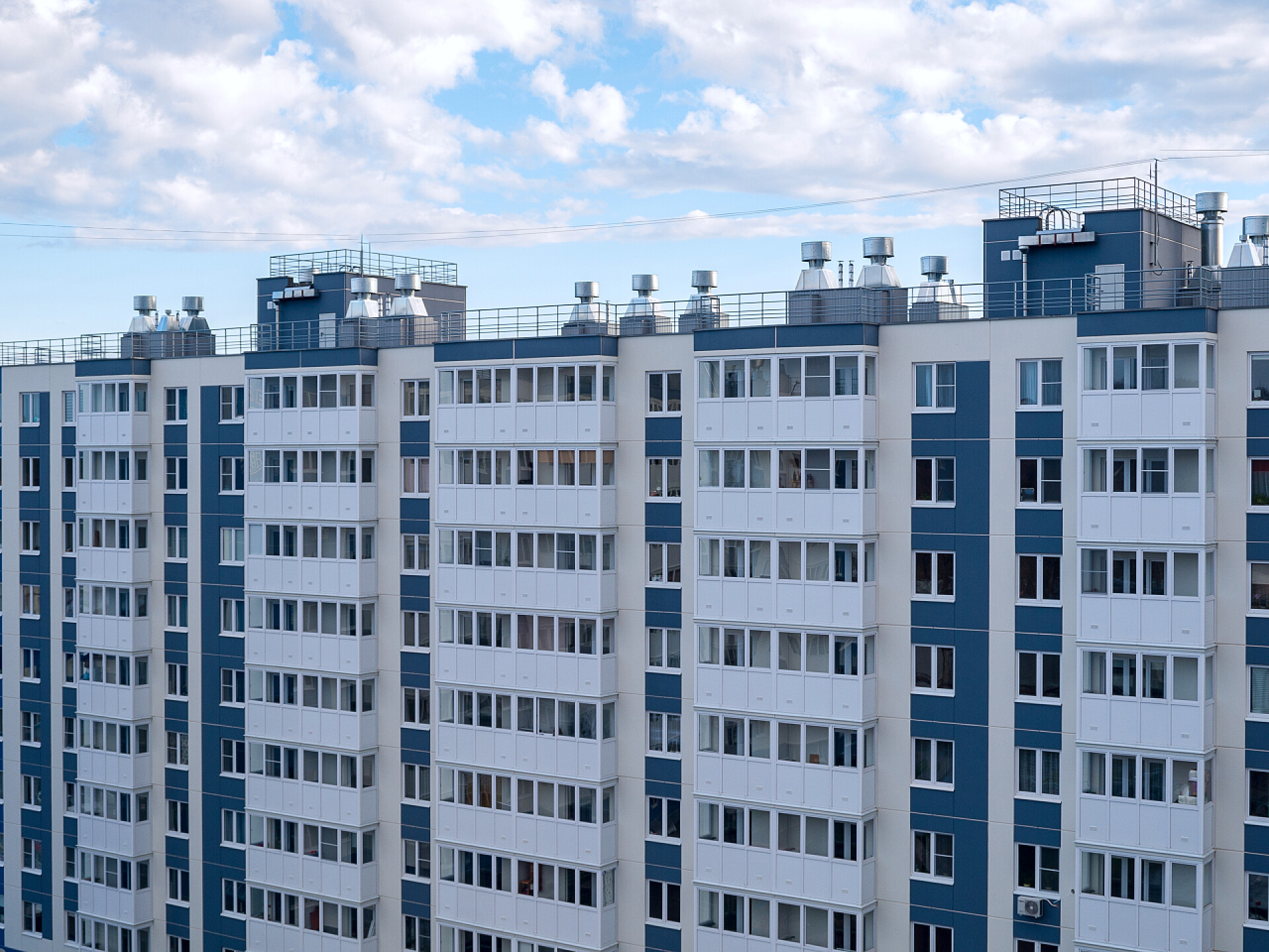 蓝天白云下的多楼层住宅多公寓多层住宅楼、嵌板式新建筑、翻新、城市新住宅区景观