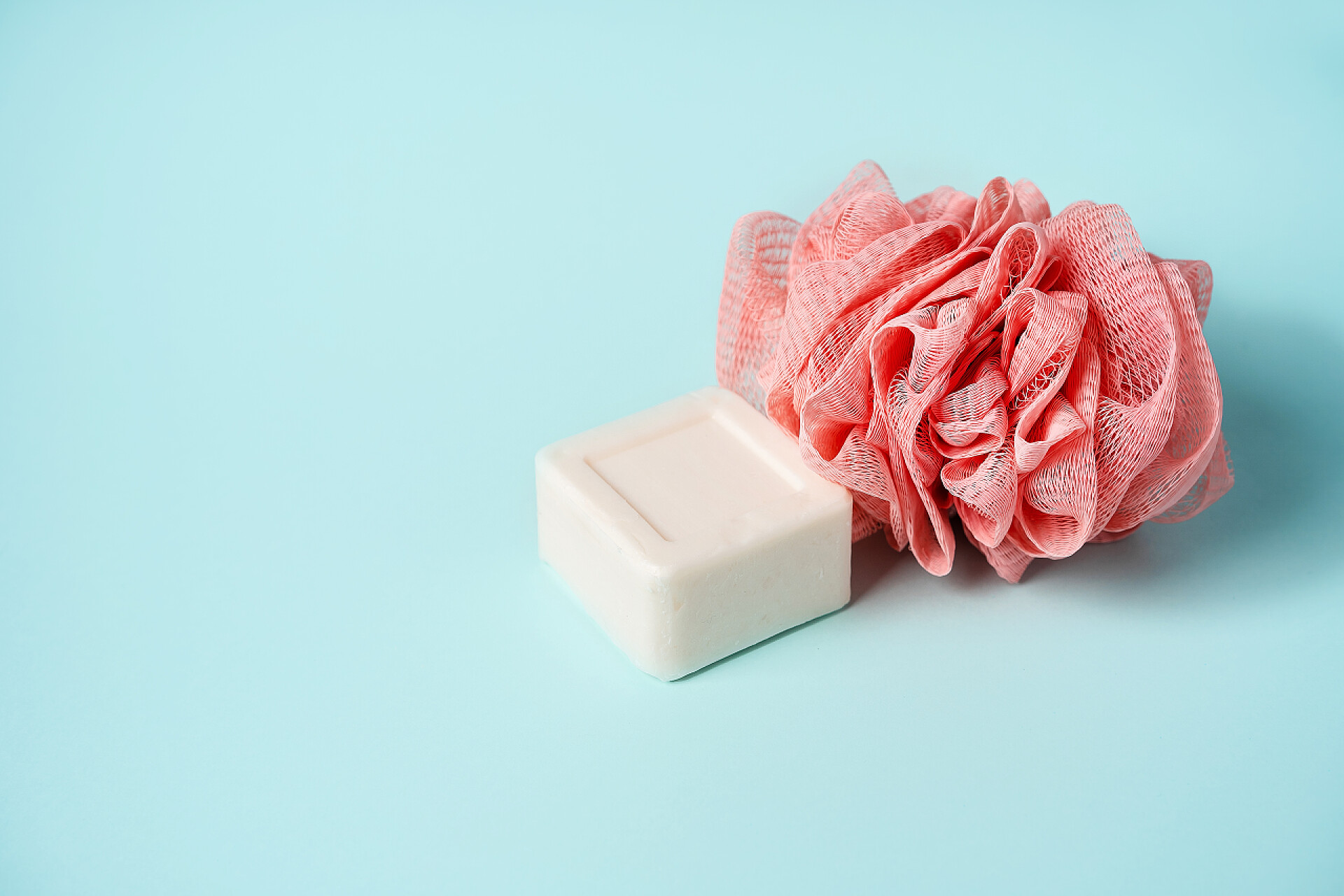 蓝色桌子上的香皂的浴花肥皂和毛巾肩并肩地躺在一起，形成一张脸，清洁和卫生的概念，健康.