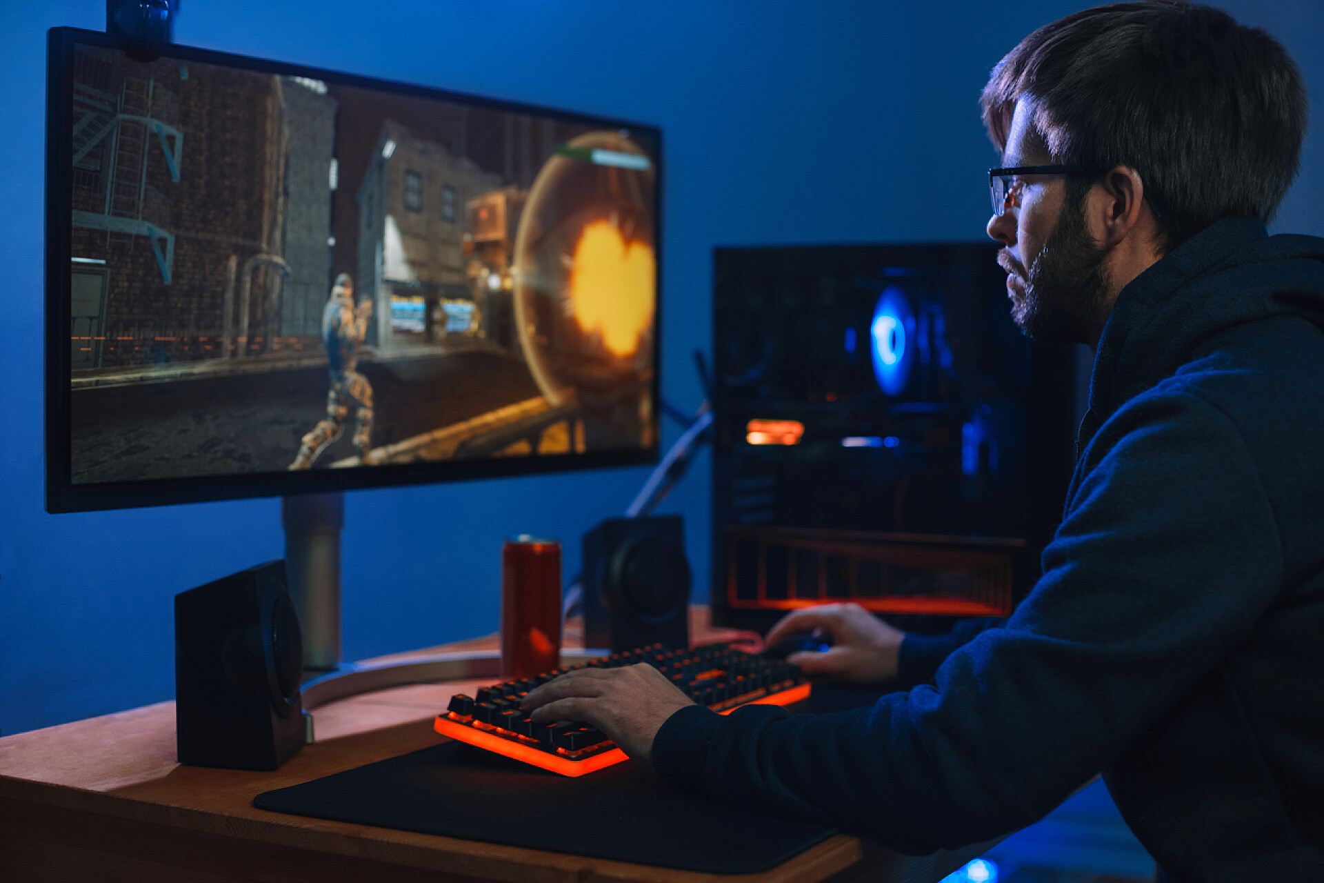 在打游戏的男人年轻的白种人职业游戏玩家在他家里的房间里玩网络游戏。人类网络运动员和他的团队一起参加比赛。侧视图。计算机依赖概念