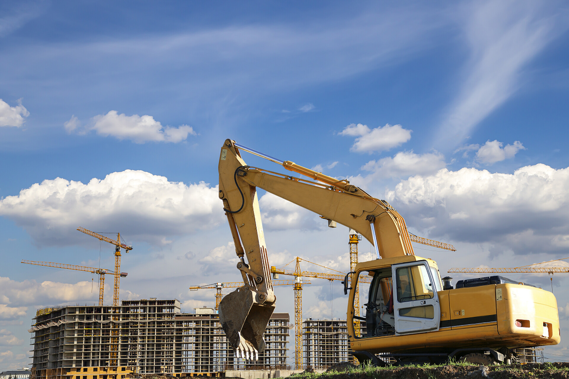 蓝天白云下的挖掘机MOSCOW, RUSSIA AUGUST 18, 2013：Construction machine (excavator) on the background construction site, industrial image.     